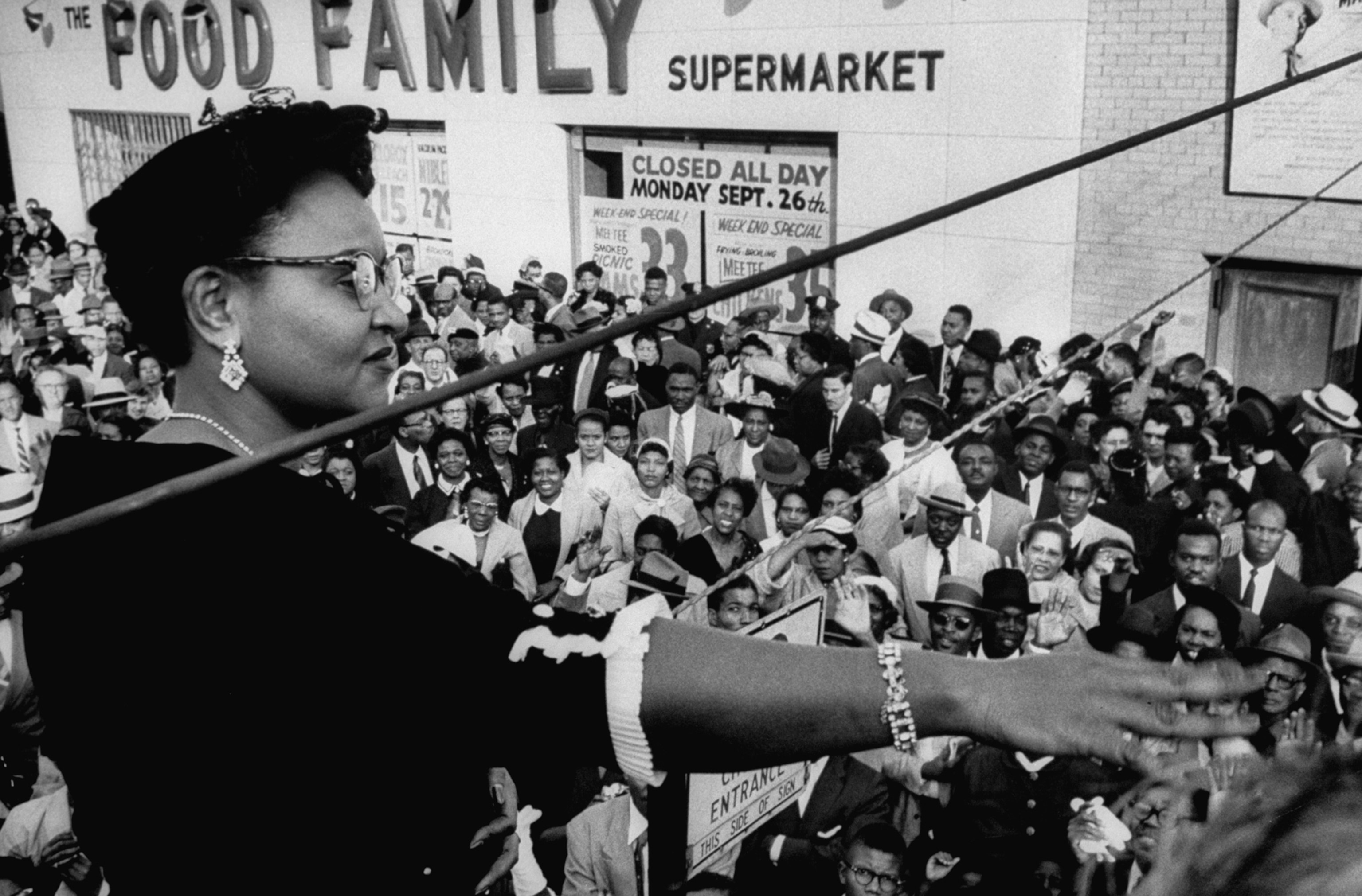 Mamie Bradley with her arm up speaking with to a group of people below her