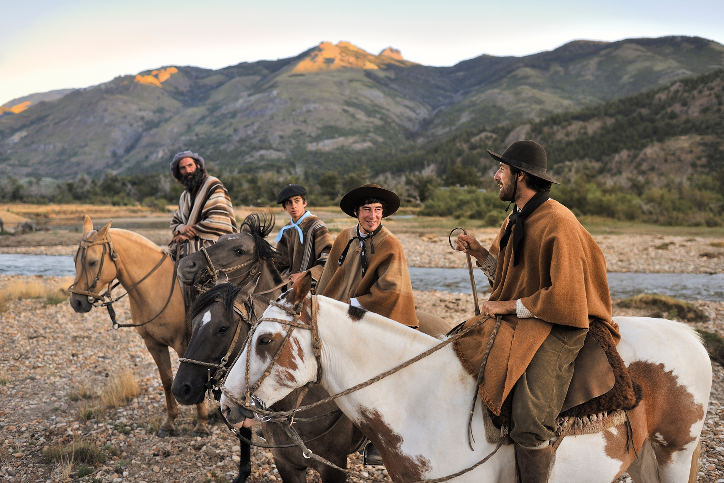 Men on horseback taking a break, chatting and drinking water