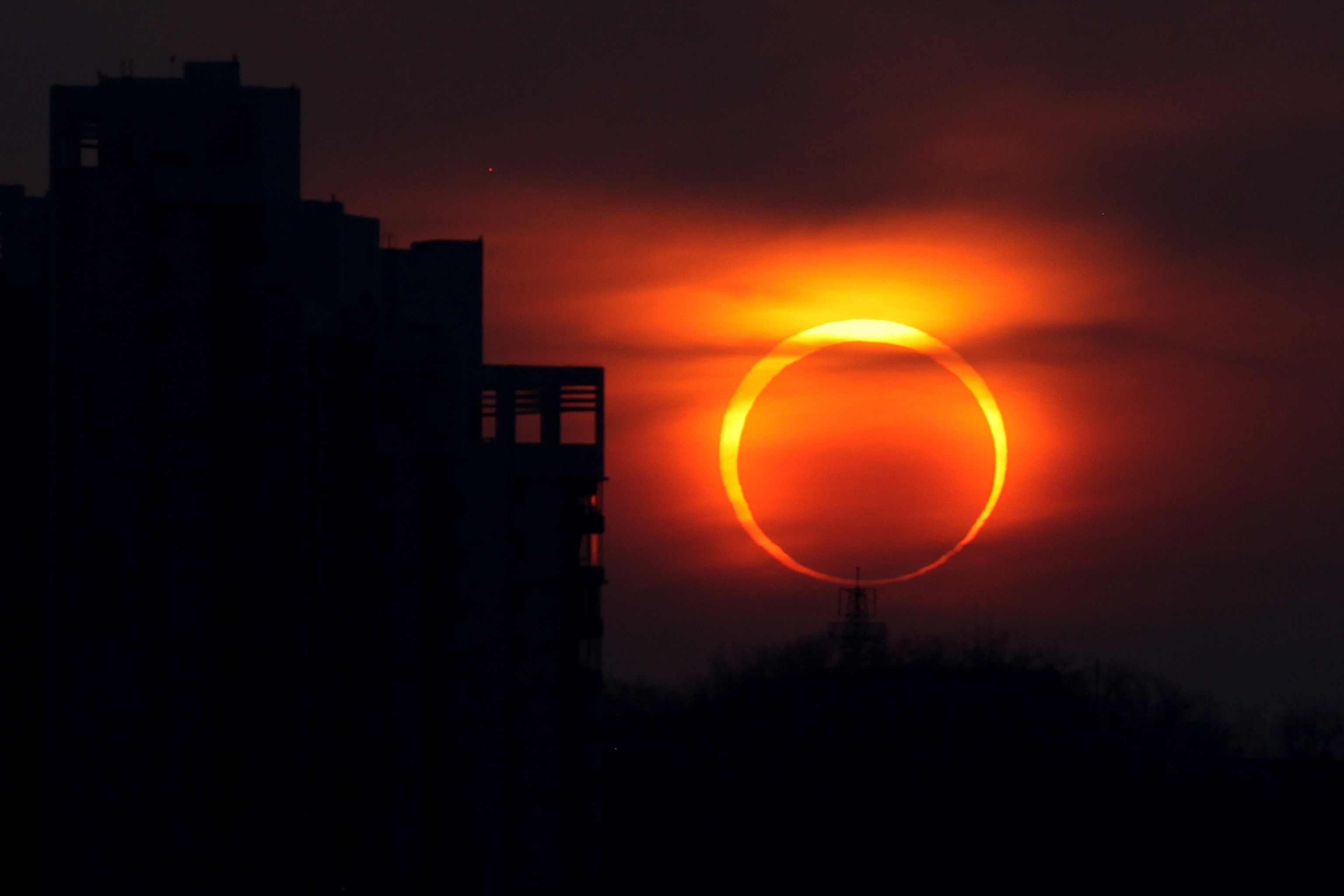 A "ring of fire" rises above the horizon.