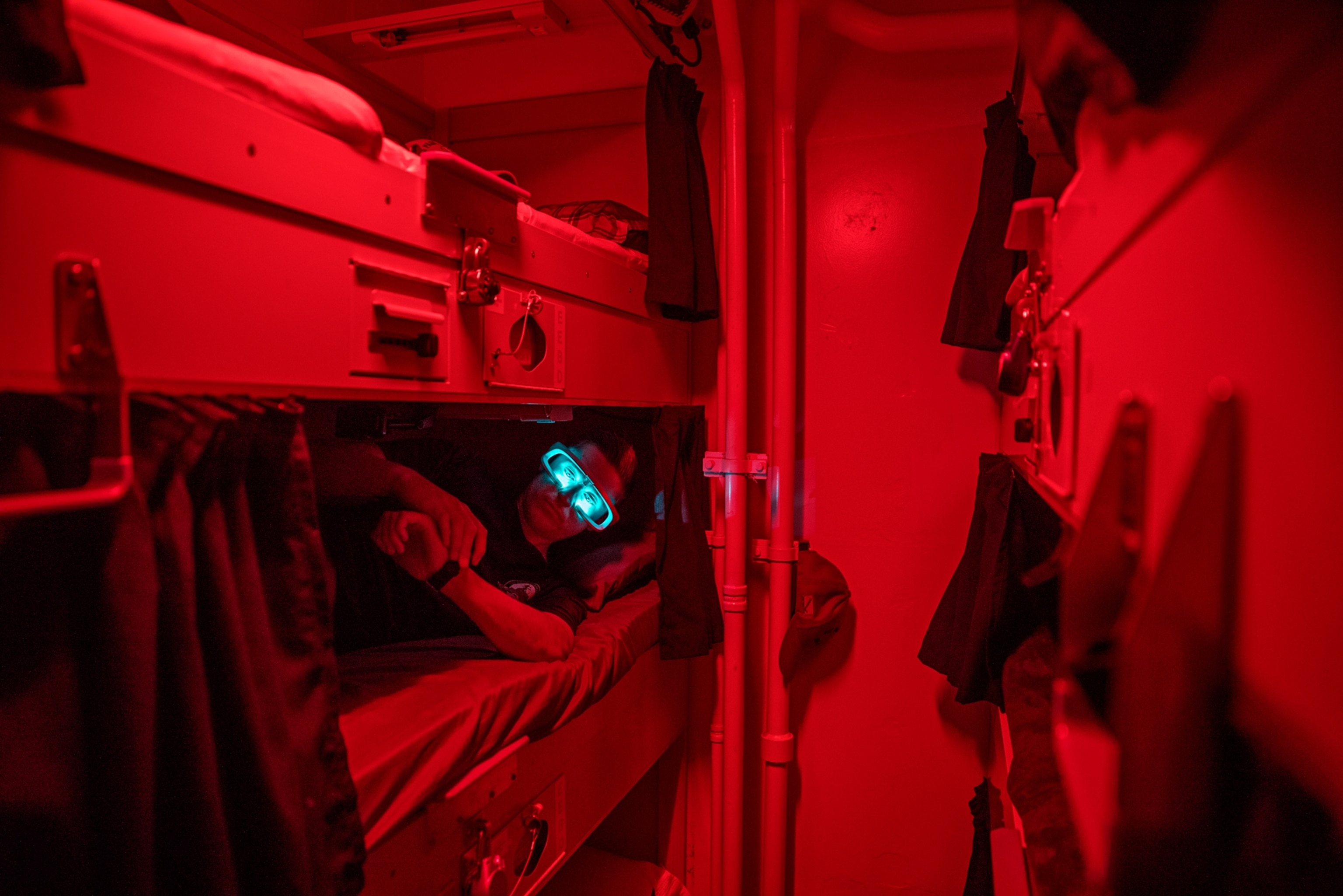 a sailor wearing glasses emitting blue light as he is checking his watch
