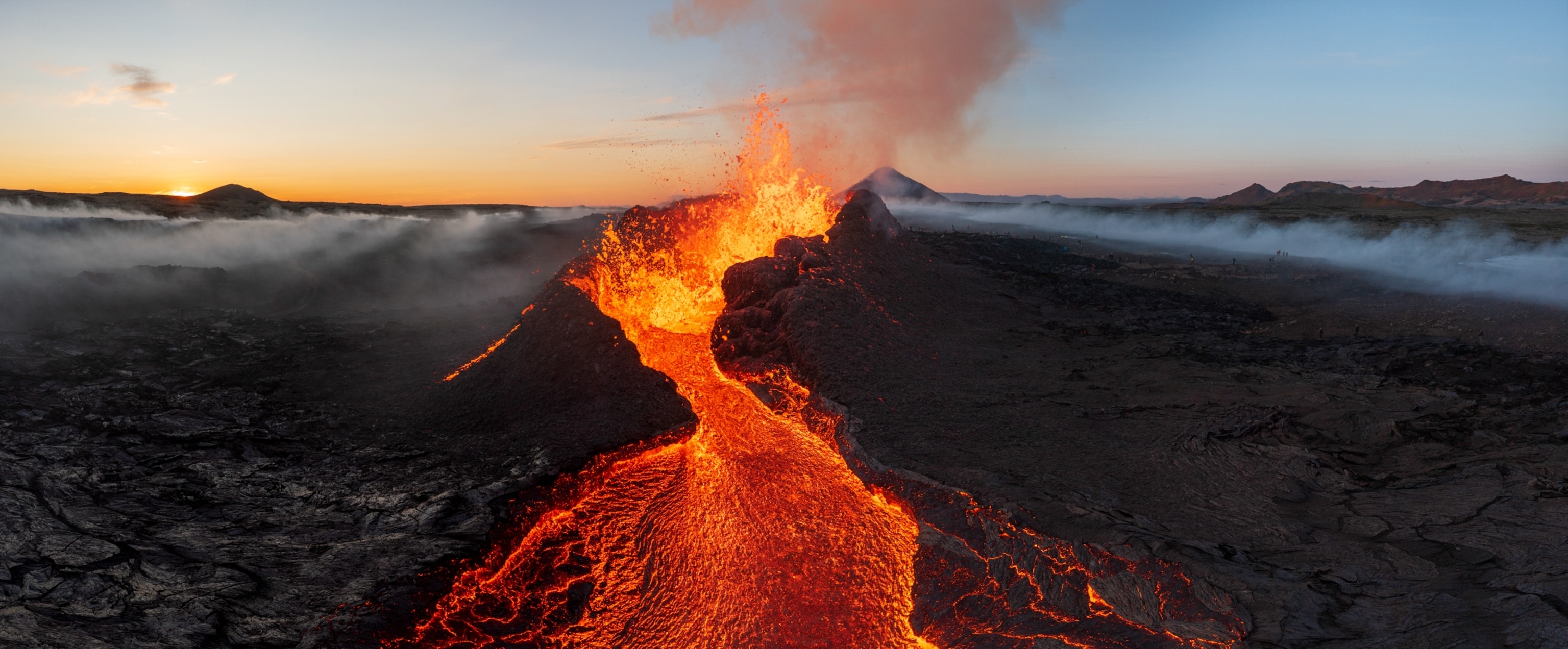 An aerial view of the main cinder cone spewing molten rock at sunset during the 2023 eruption at Fagradalsfjall.