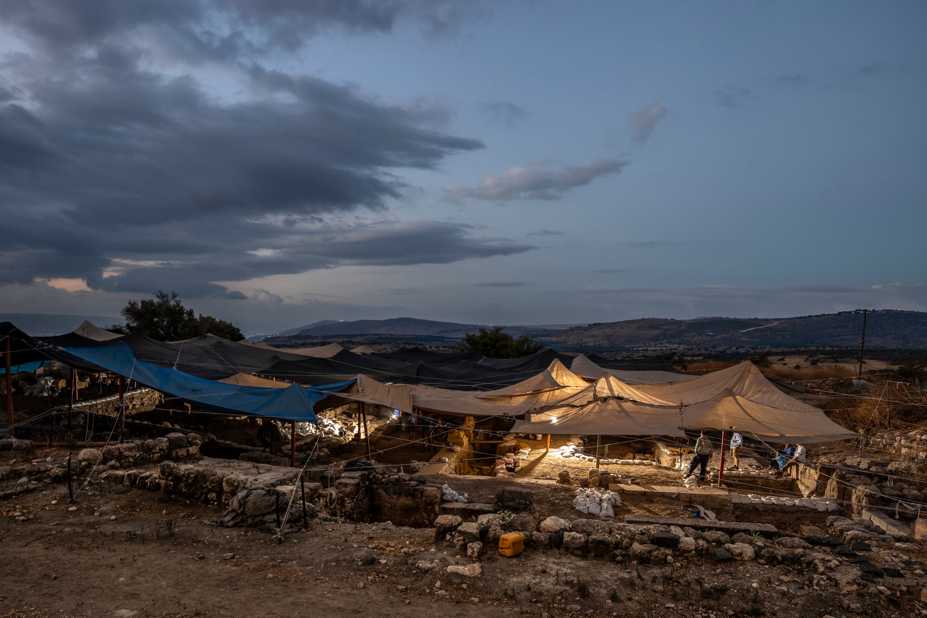 Shade nets above the excavation site at dusk.