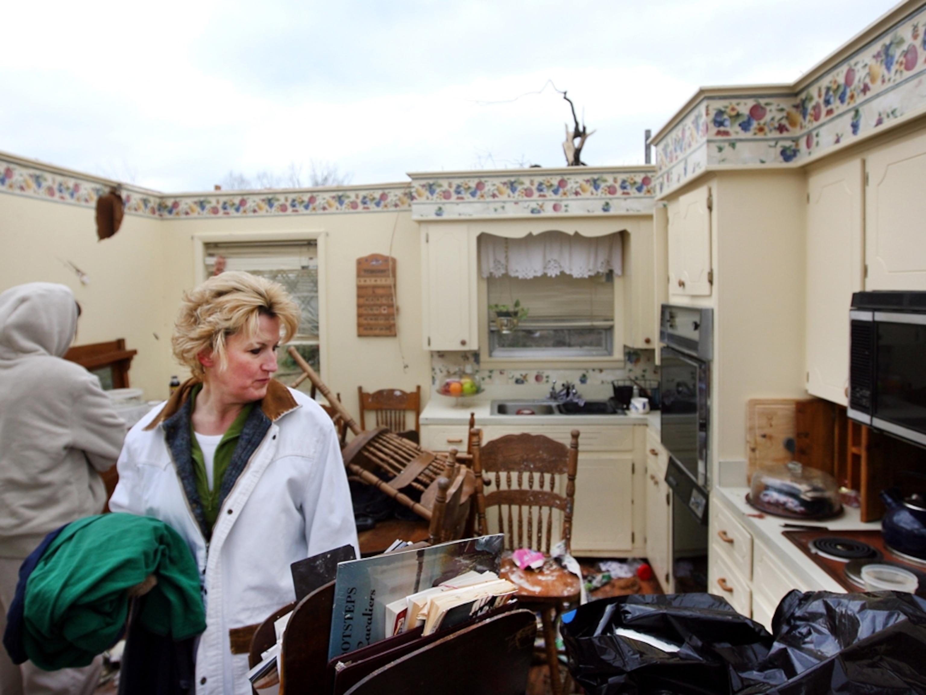 A woman searching the wreckage of a house