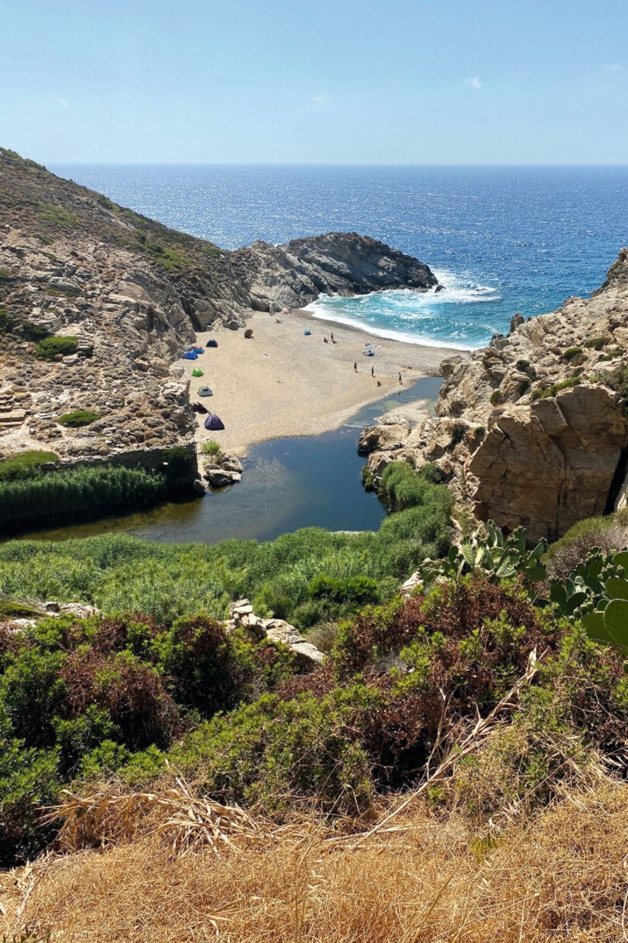 A sandy bay with tents, on Ikaria.