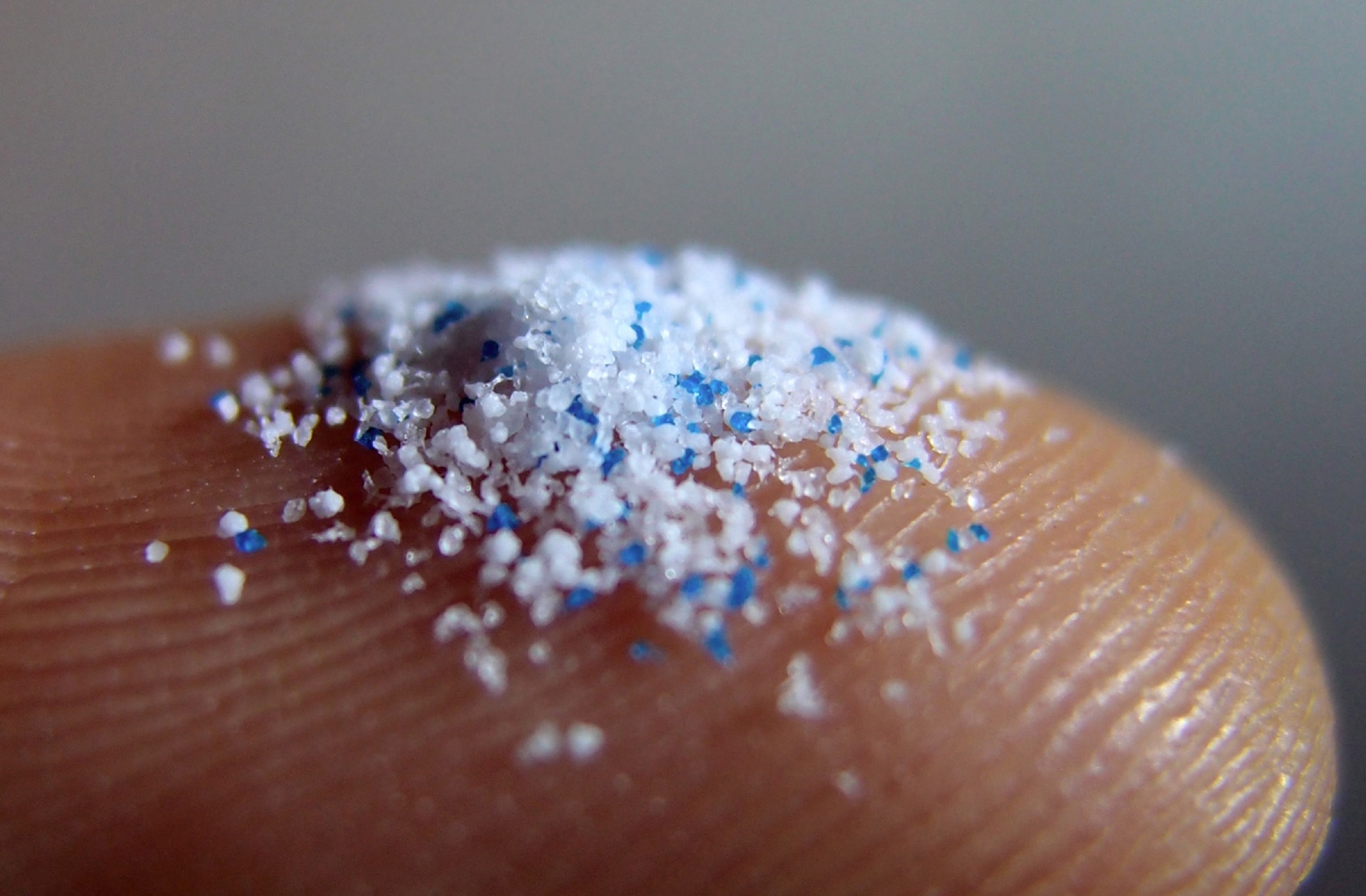 small plastic particles rest on a finger