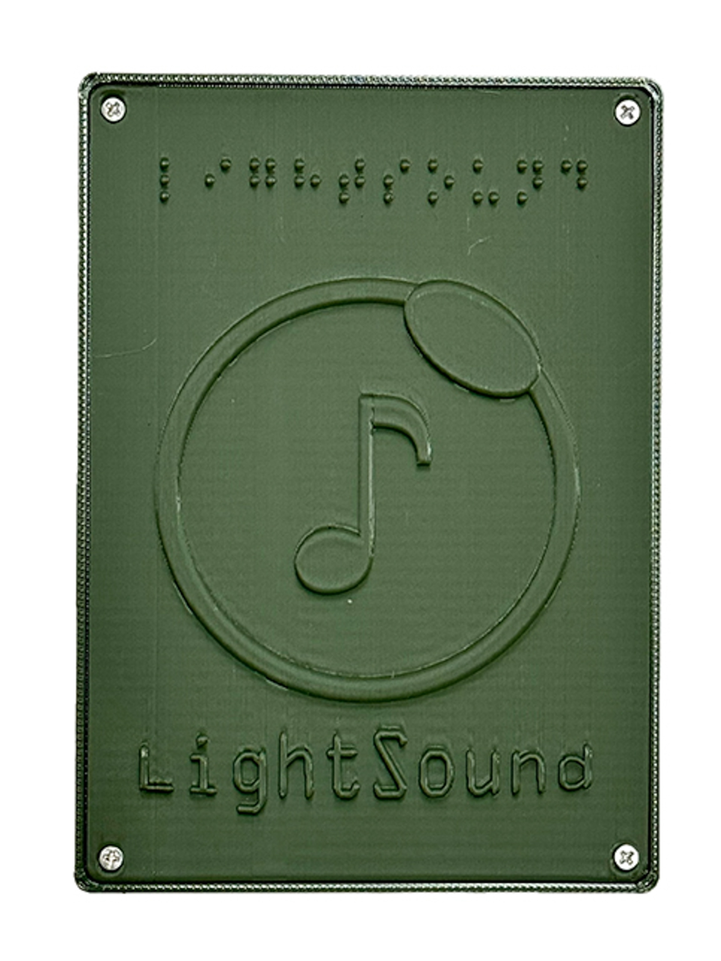 A studio shot of the LightSound device, which is a green green box labeled both in Braille and English.
