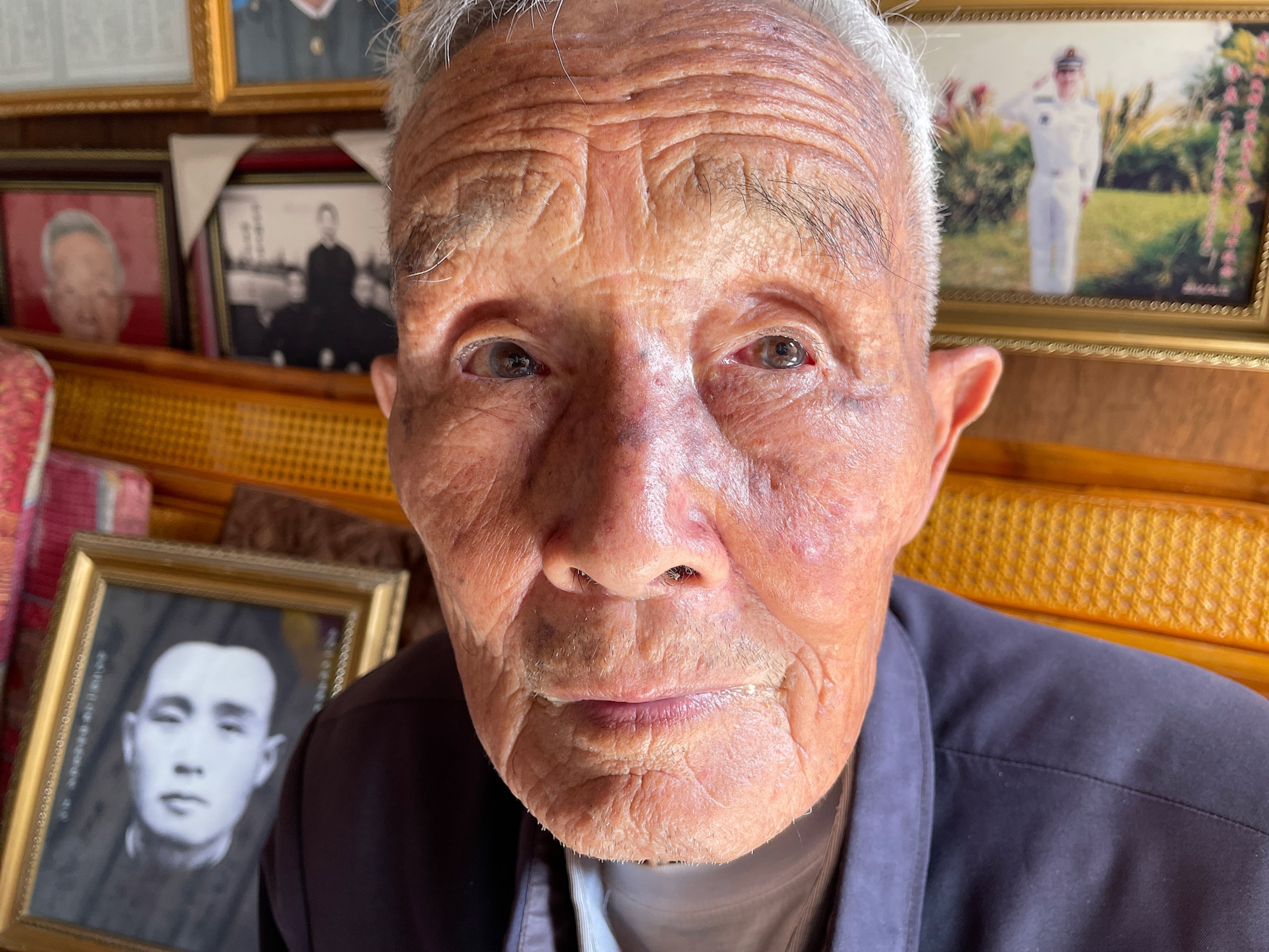 Photo of Xu Ben Shen with black and white photo of him as a younger man in background