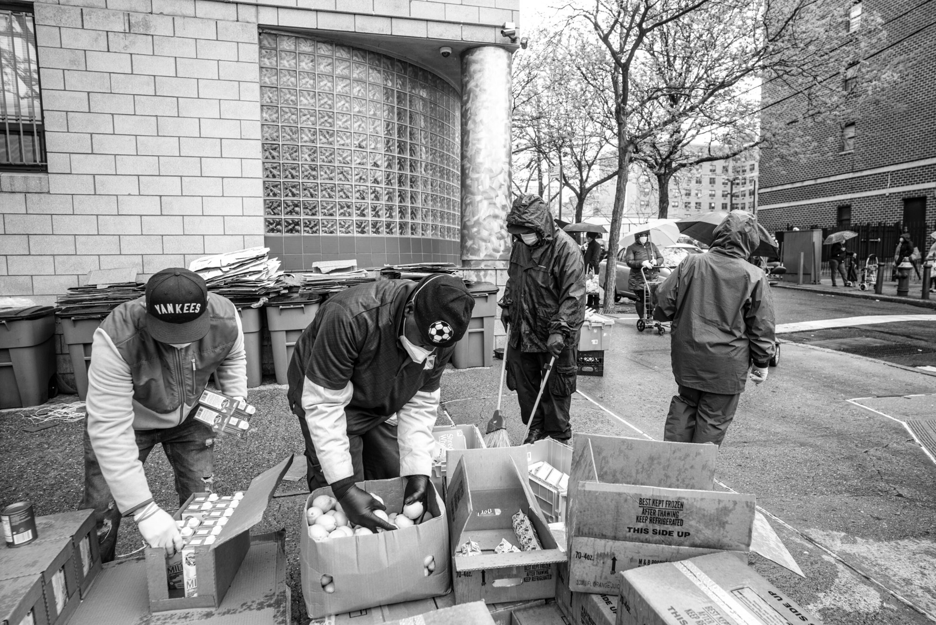 a few people packing boxes with food outside of a building