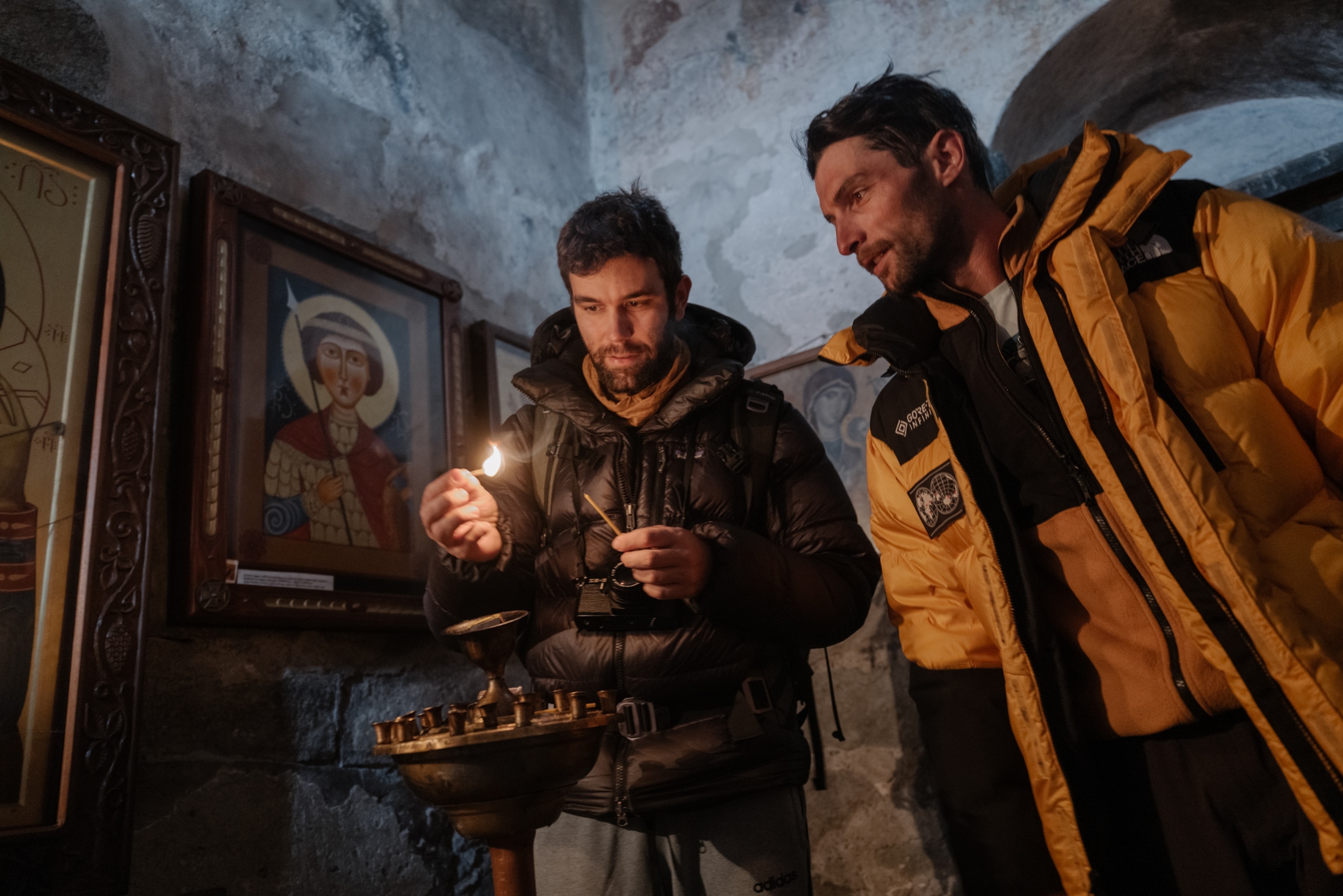 Tourists light candles in the Lamaria Church in Ushguli