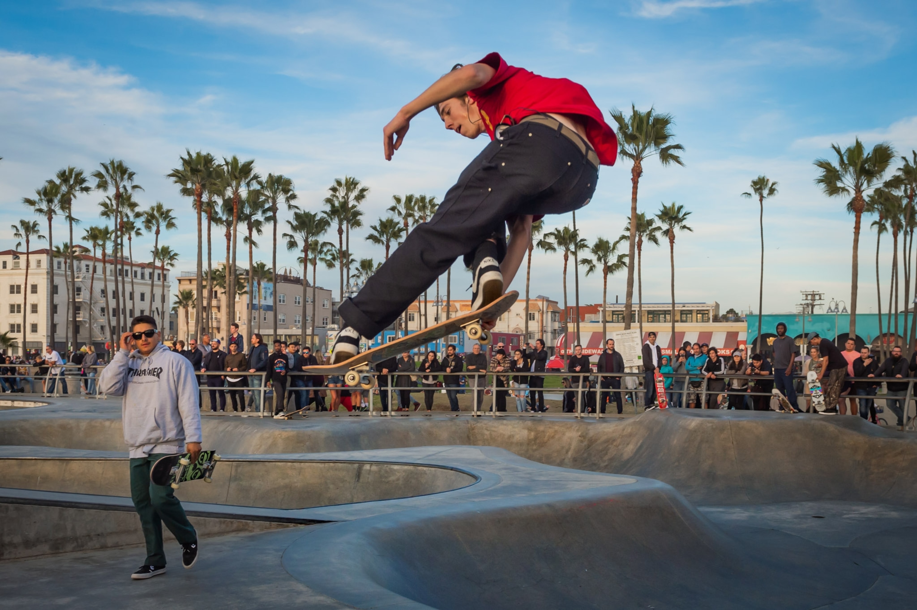 a skateboarder mid air, while people watch alongside a railing