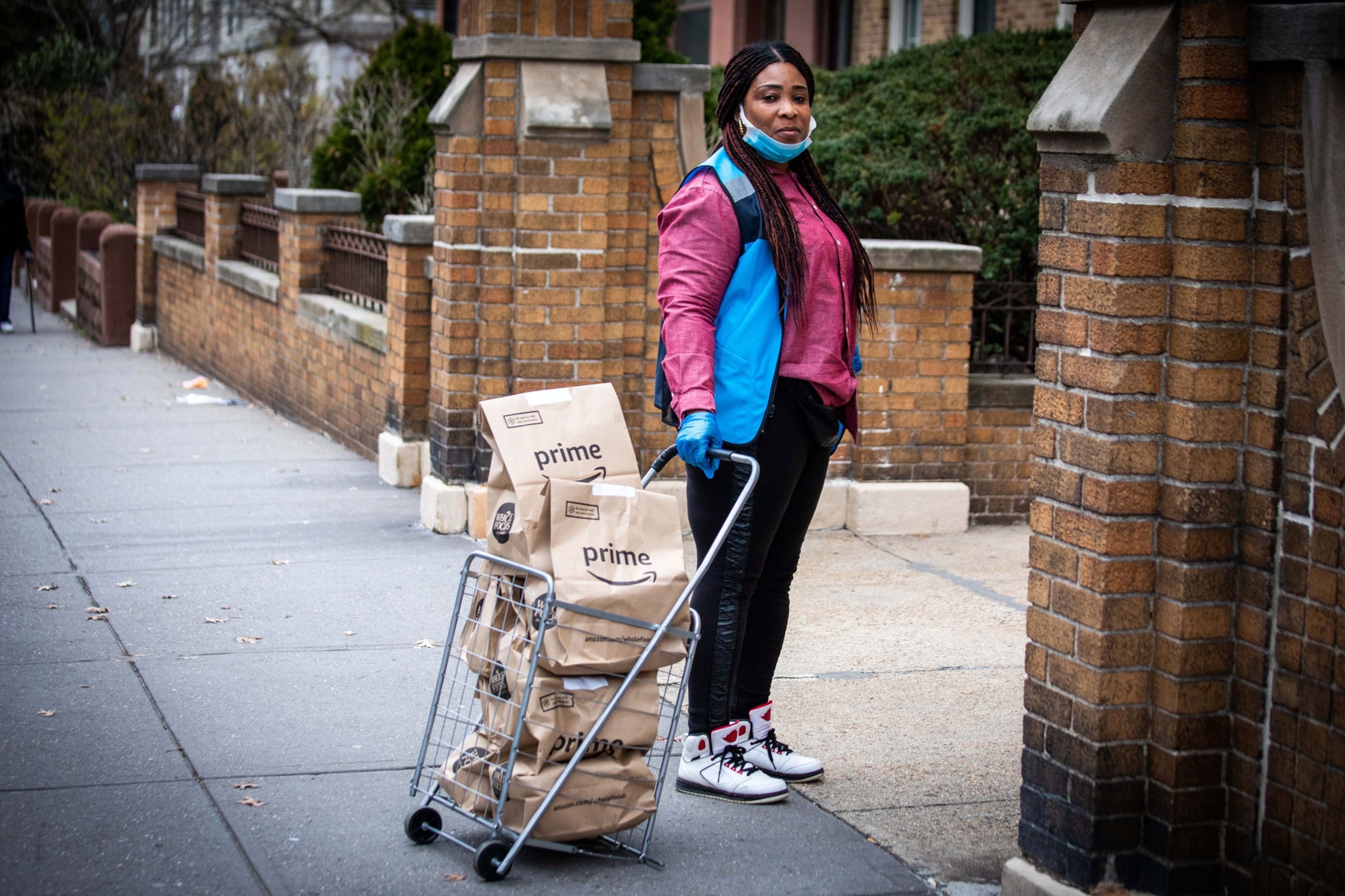 a woman with a basket full of brown paper bags with Amazon Prime logos