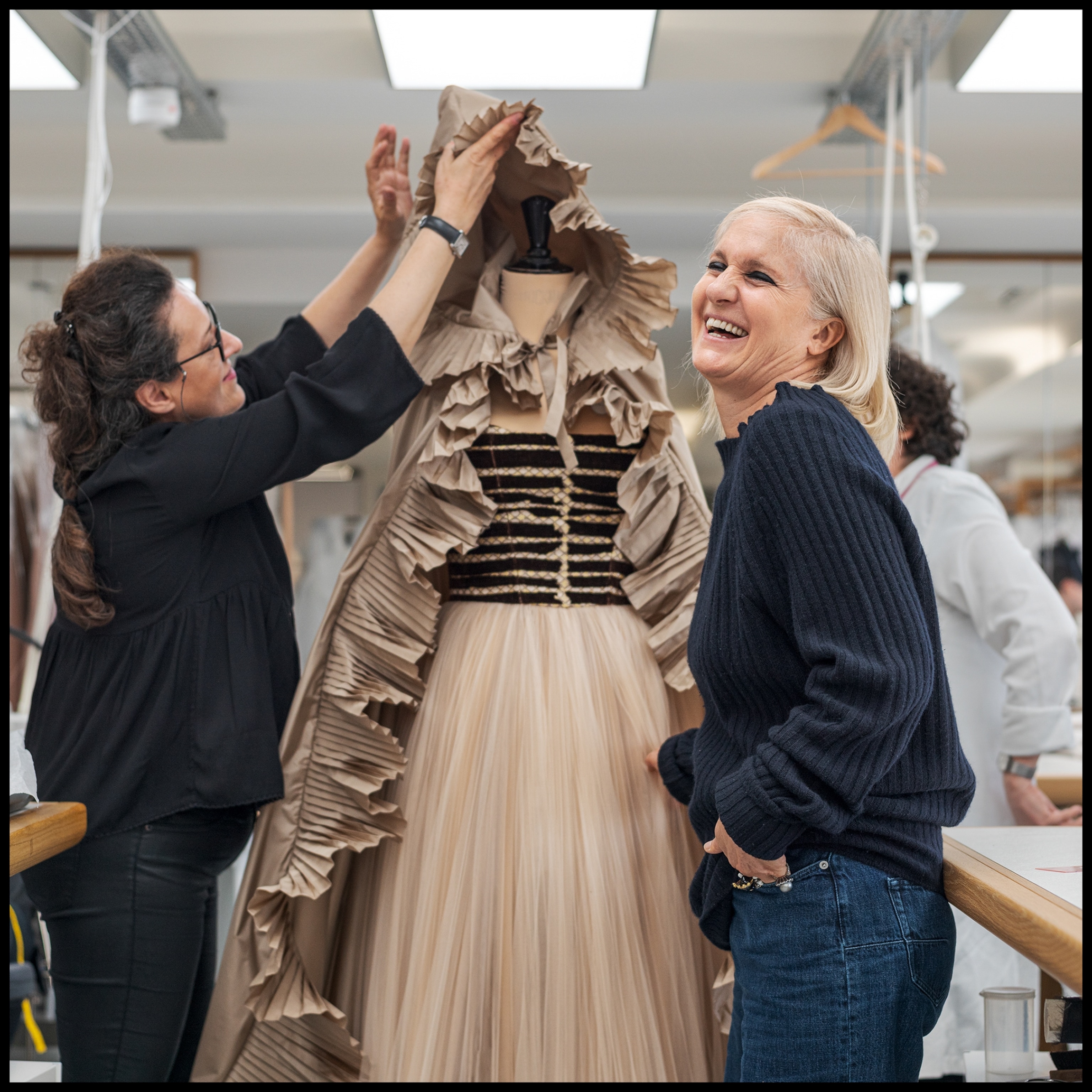 two designers standing along a dressed mannequin