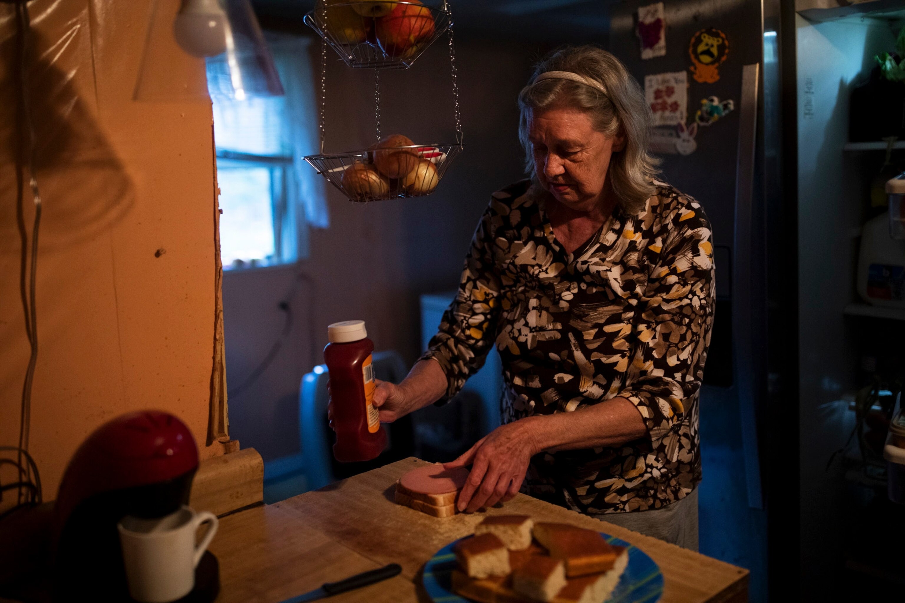 a grandmother makes a sandwich for her granddaughter