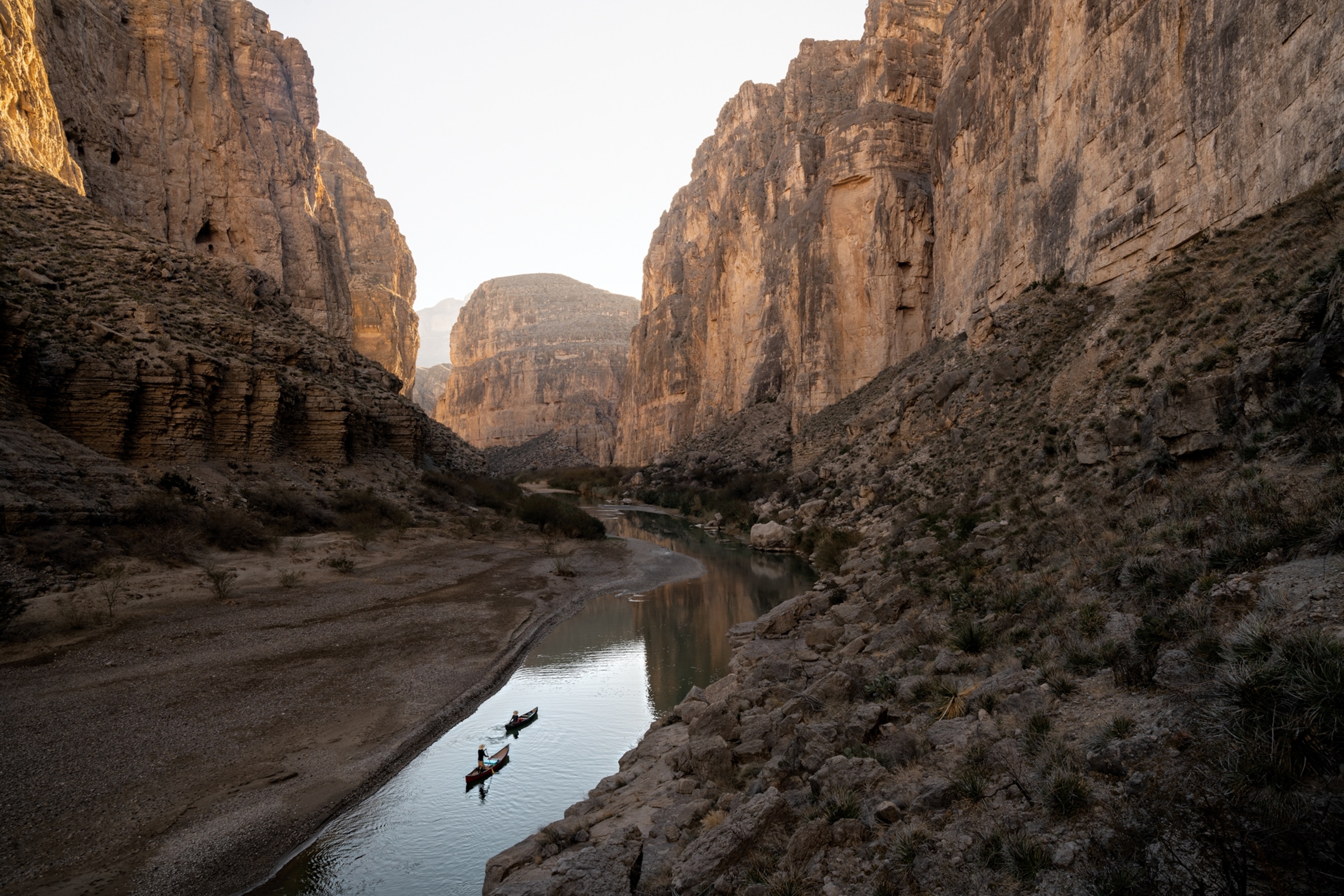 Picture of two canoes going along the river through the canyon.