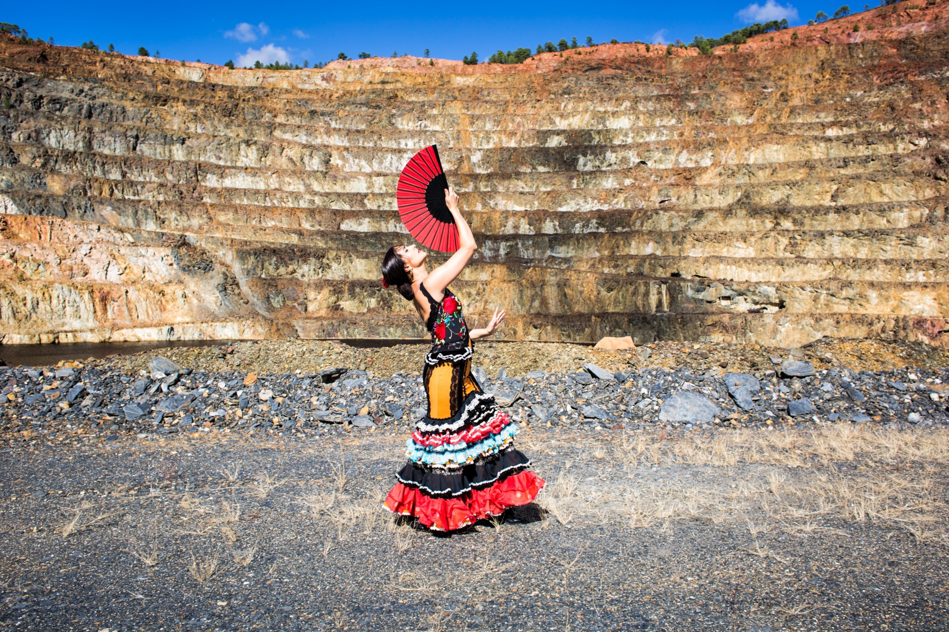 A woman with a red fan a long red dress