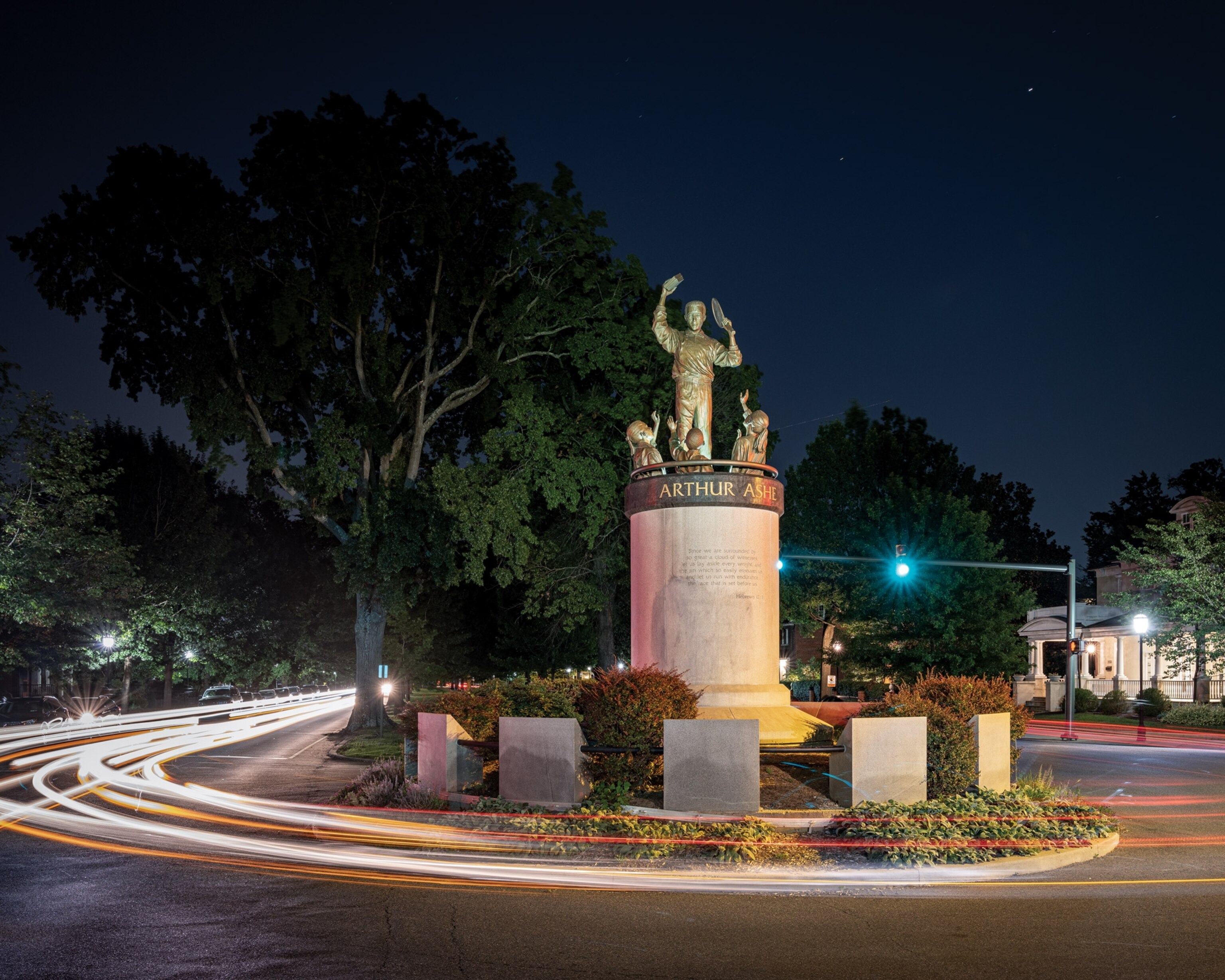 Long exposure of car lights and a statue seen at night