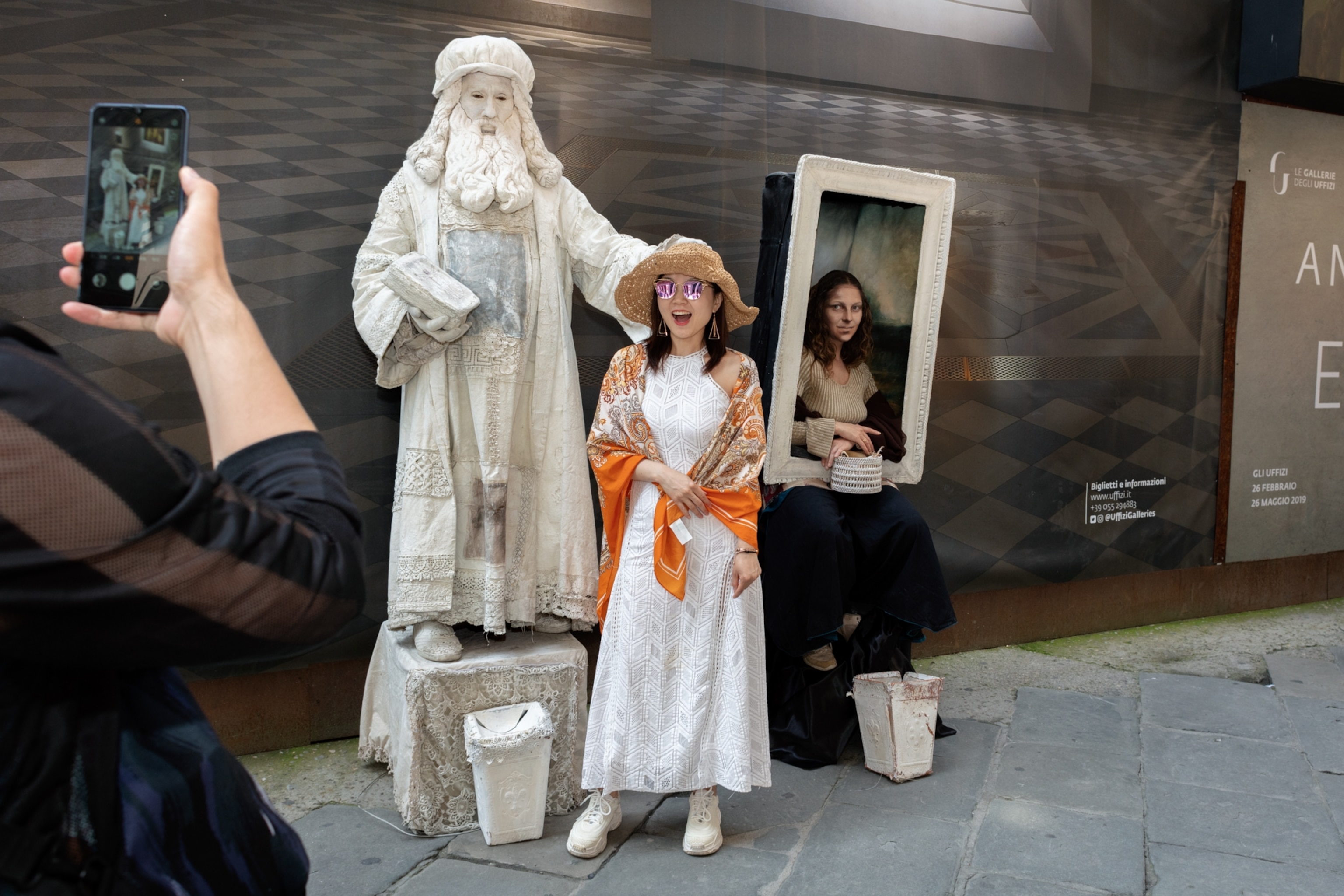 two Renaissance impersonators posing with a tourist outside