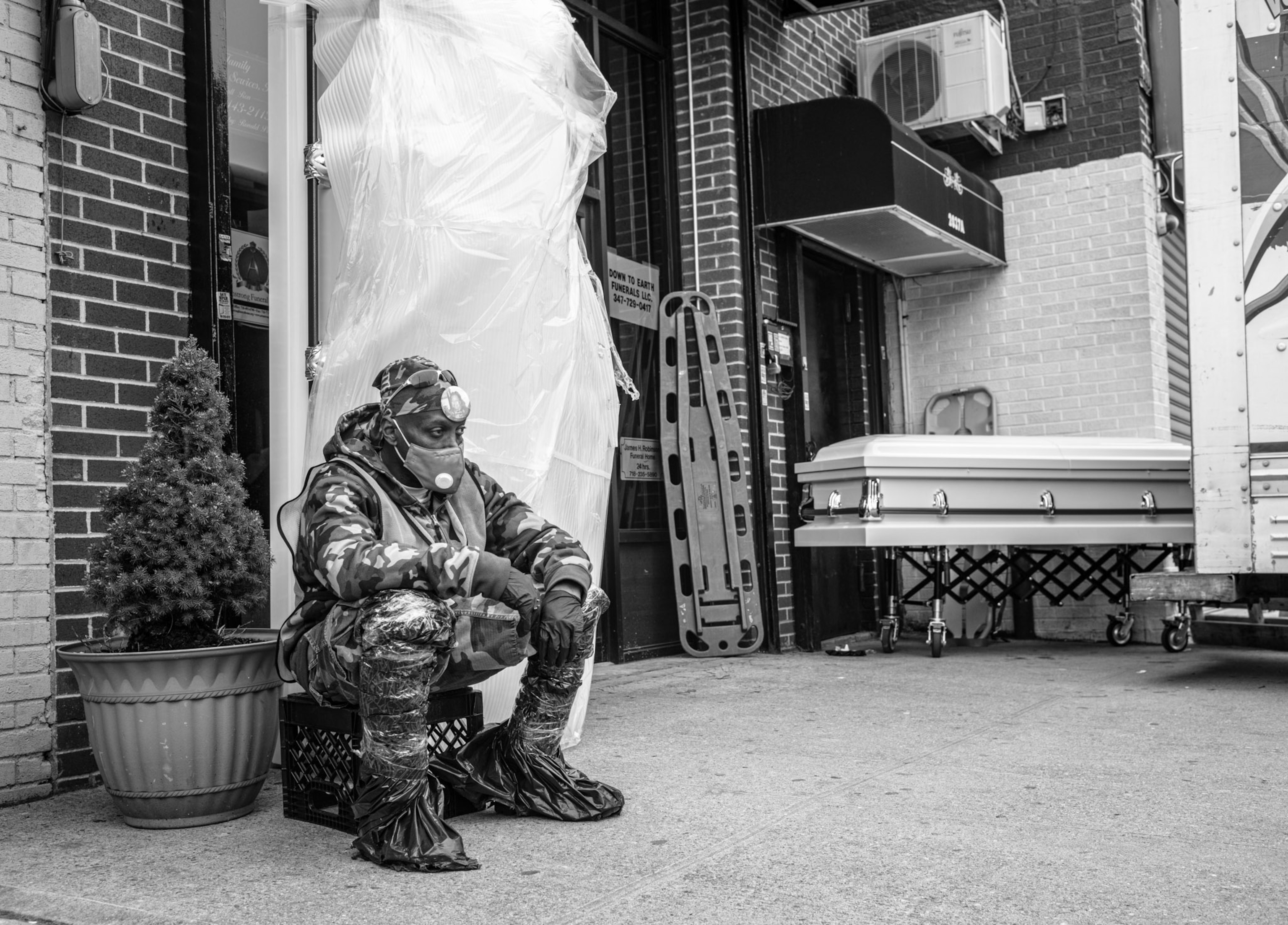 a person sitting on a milk crate outside of a door