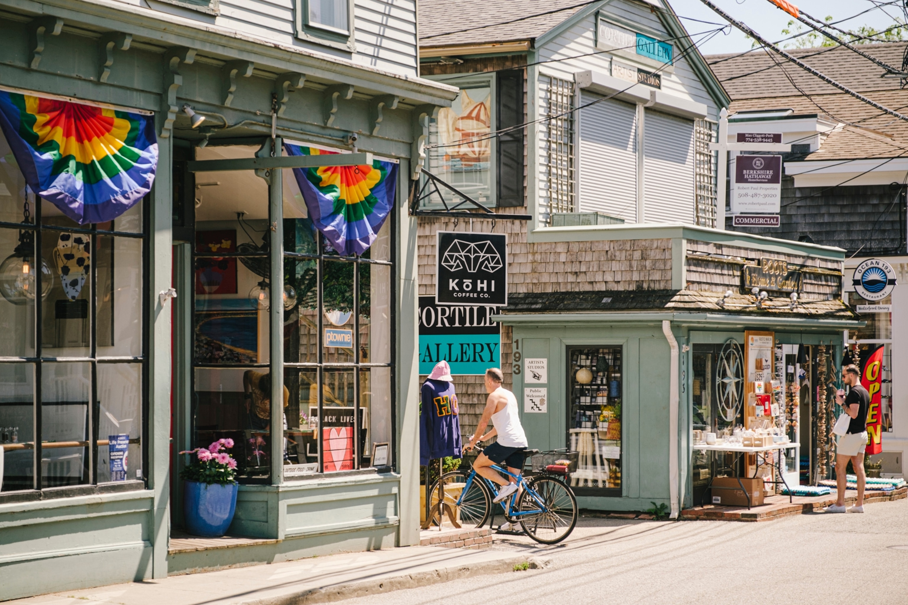 Coastal town shop fronts with rainbow flags displayed in the windows