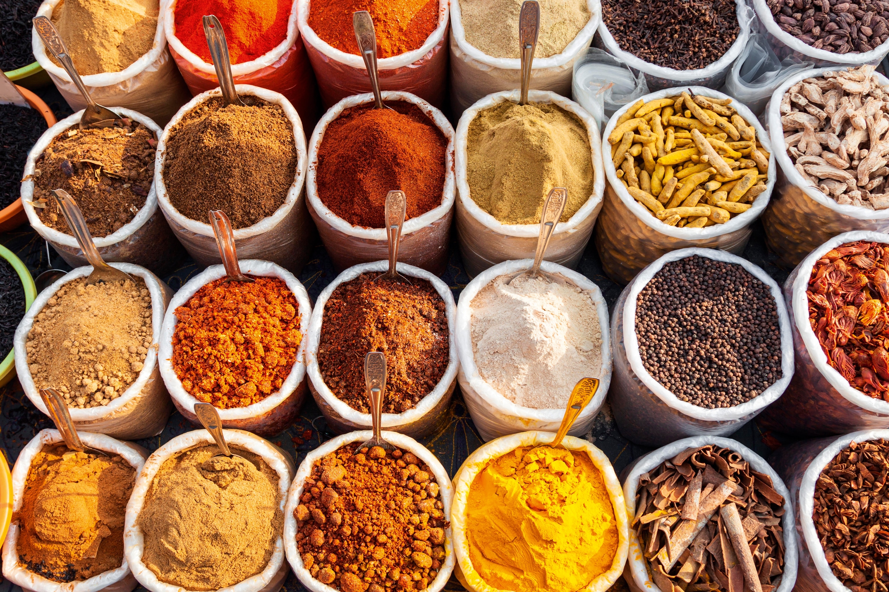 A colourful arrangement of spices in pots from above