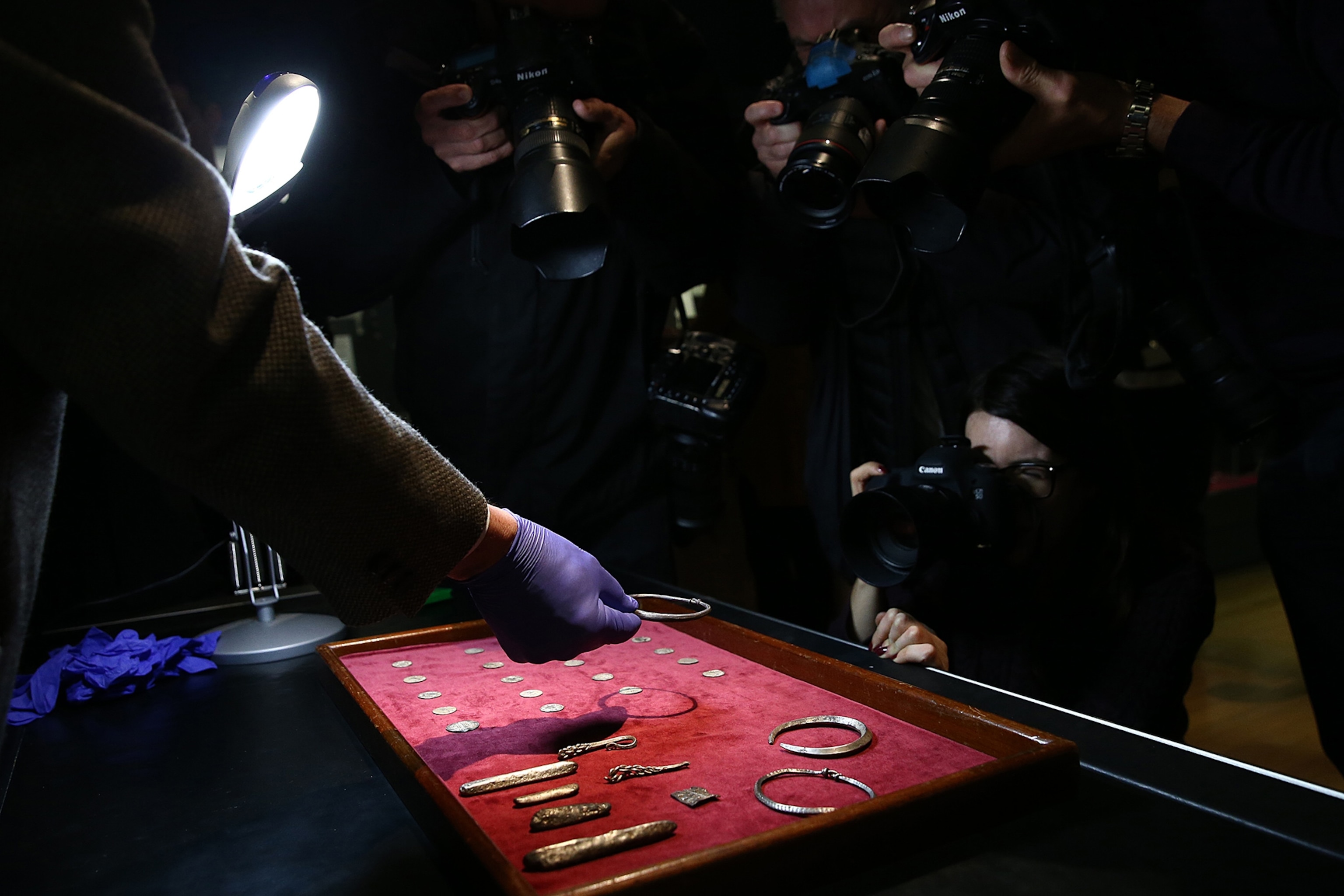 Photographers take pictures of a Viking armband during a press preview for a rare Viking hoard discovered by metal detector enthusiast James Mather, at the British Museum.