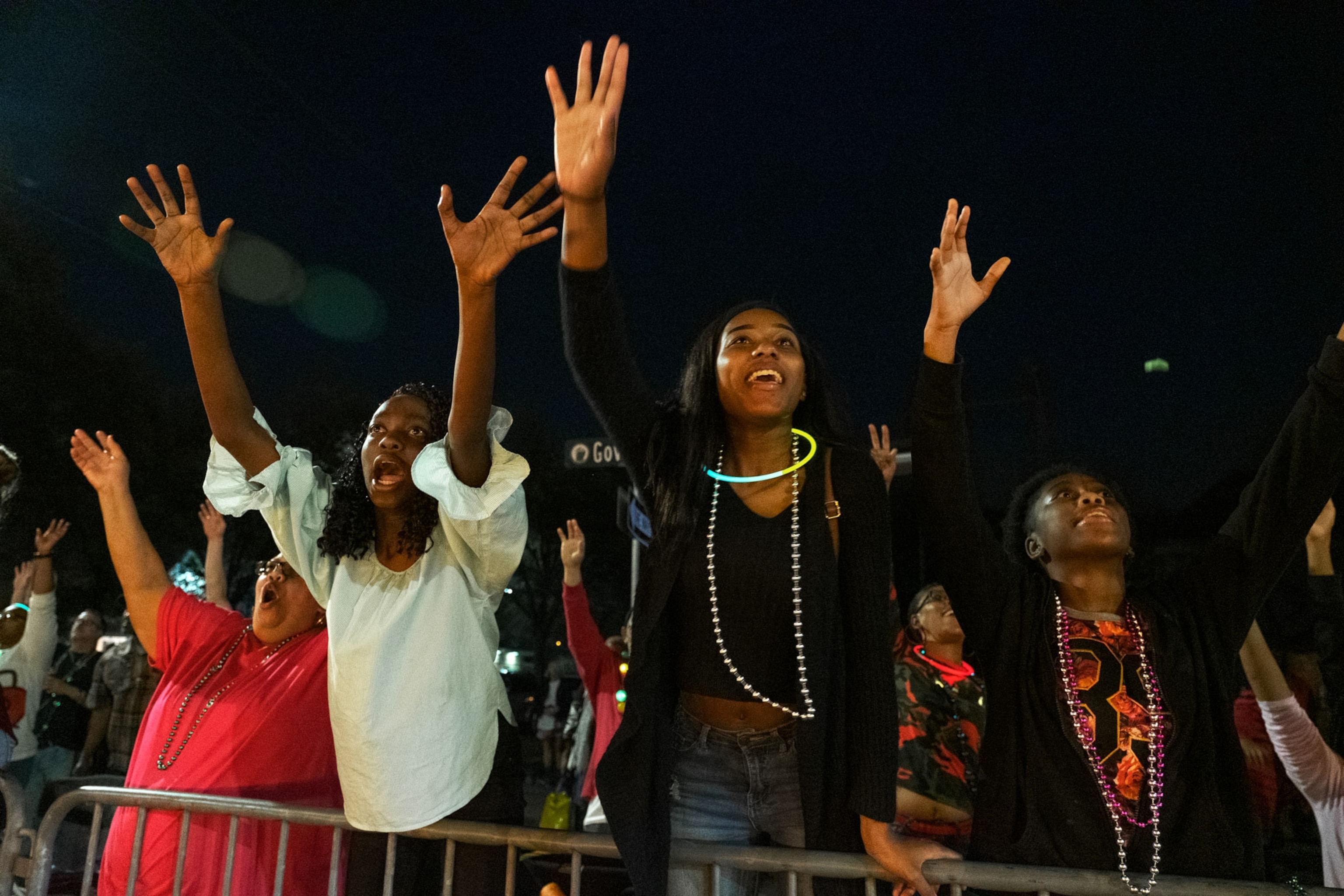 young women reaching over a parade barrier trying to catch moonpies