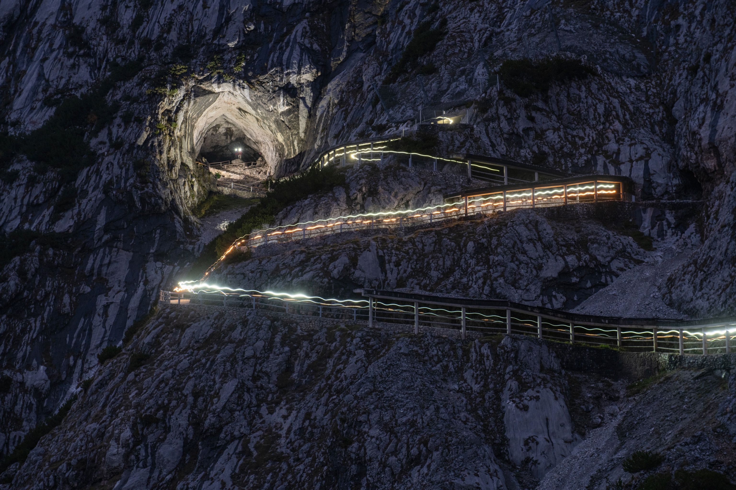 The road up to the entrance to Eisriesenwelt cave lit up by a long exposure of a car