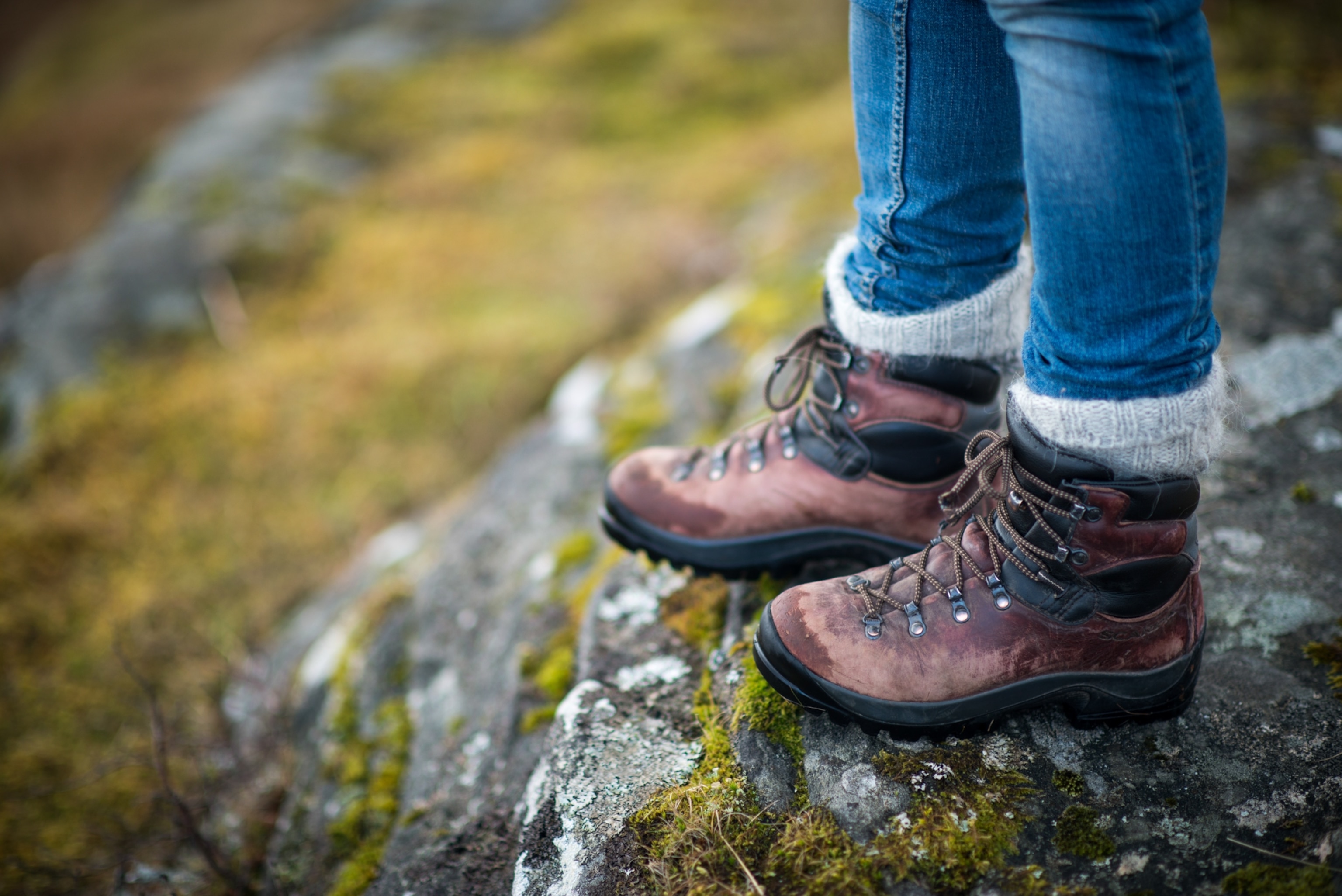 Close up of a hiker's boots, where they have tucked their pants legs into their socks.