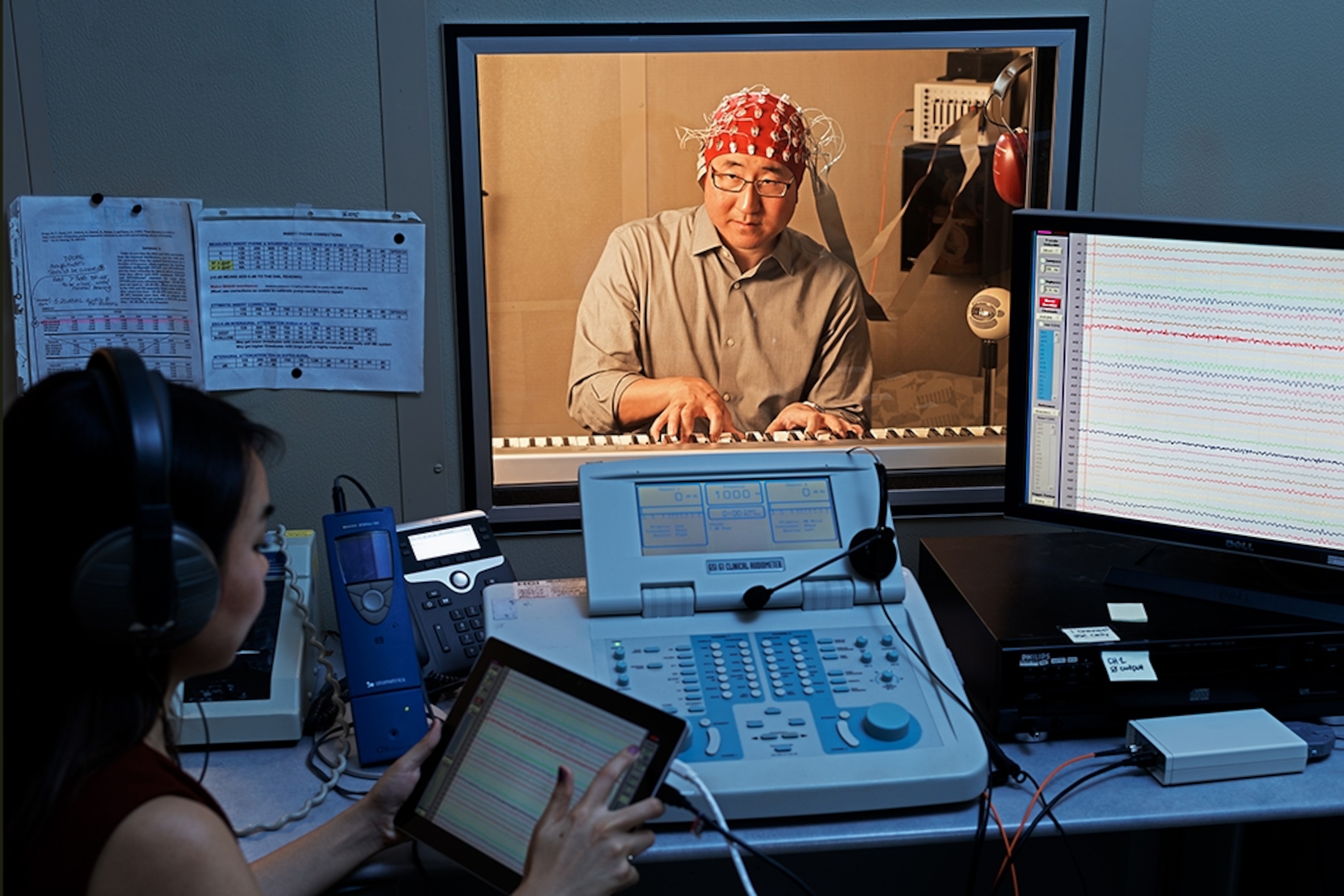 man playing keyboard with sensors attached to his head.