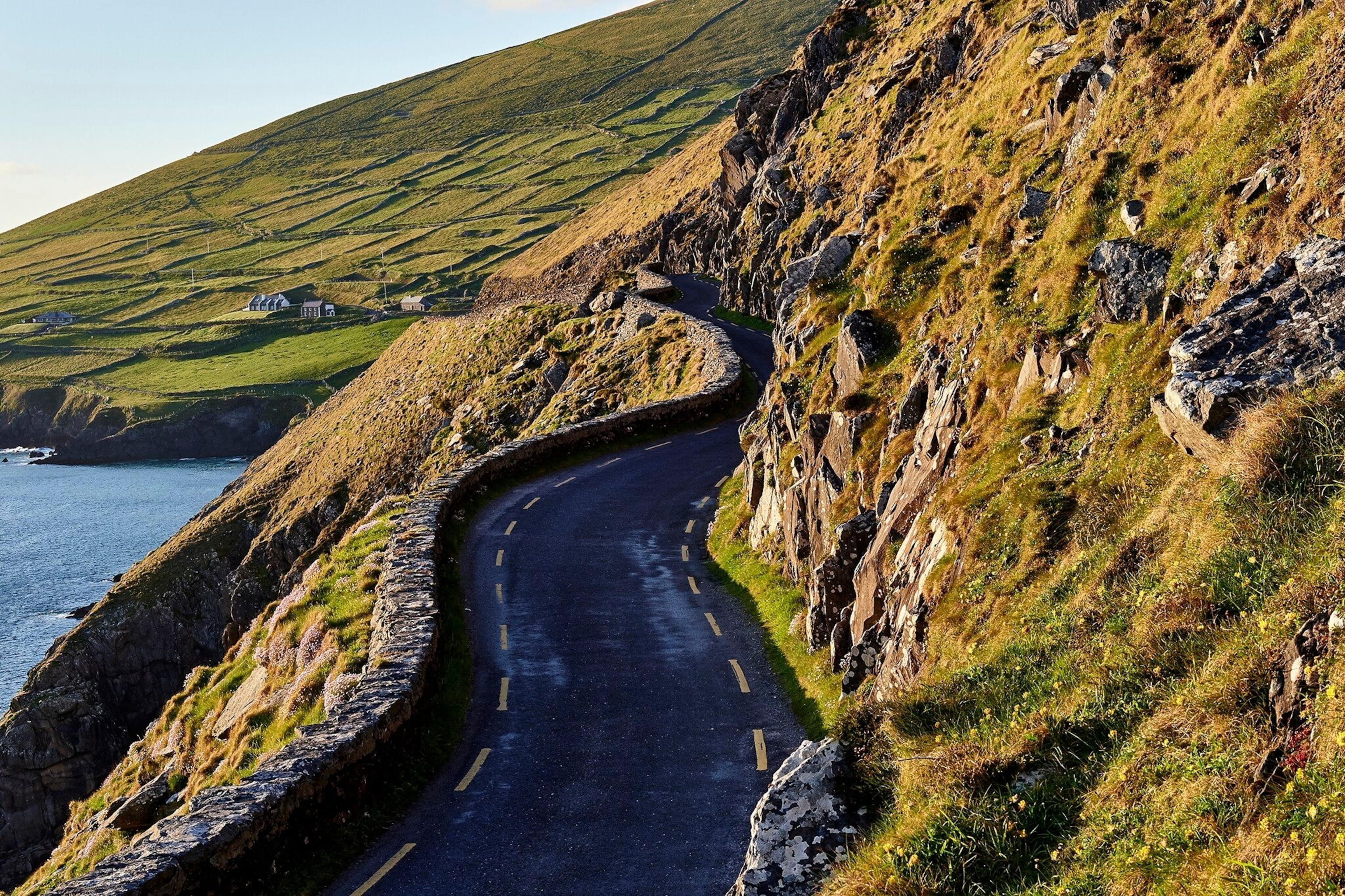 A road winds along the edge of the coast on the Wild Atlantic Way.