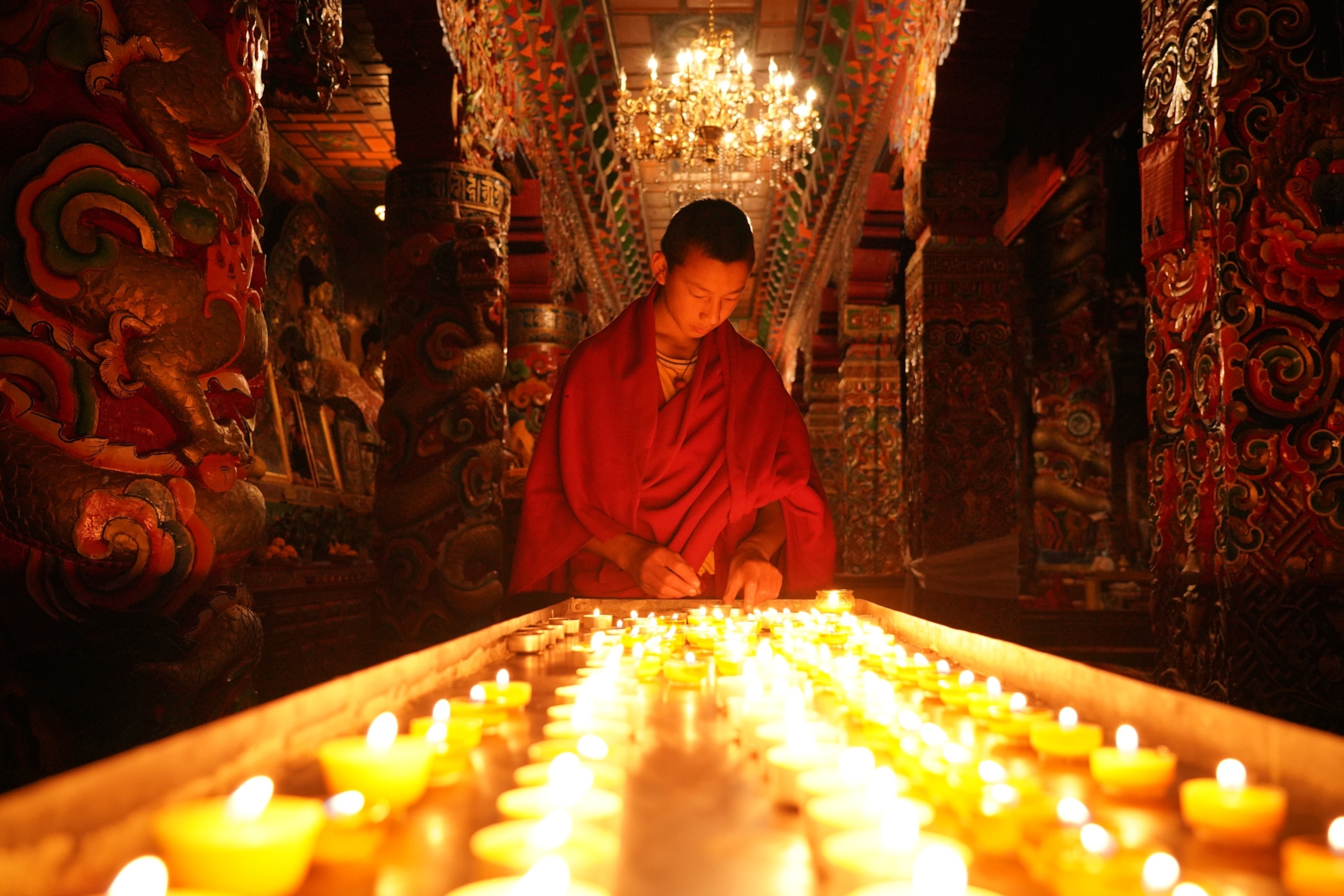 Photo of a monk lit by candles