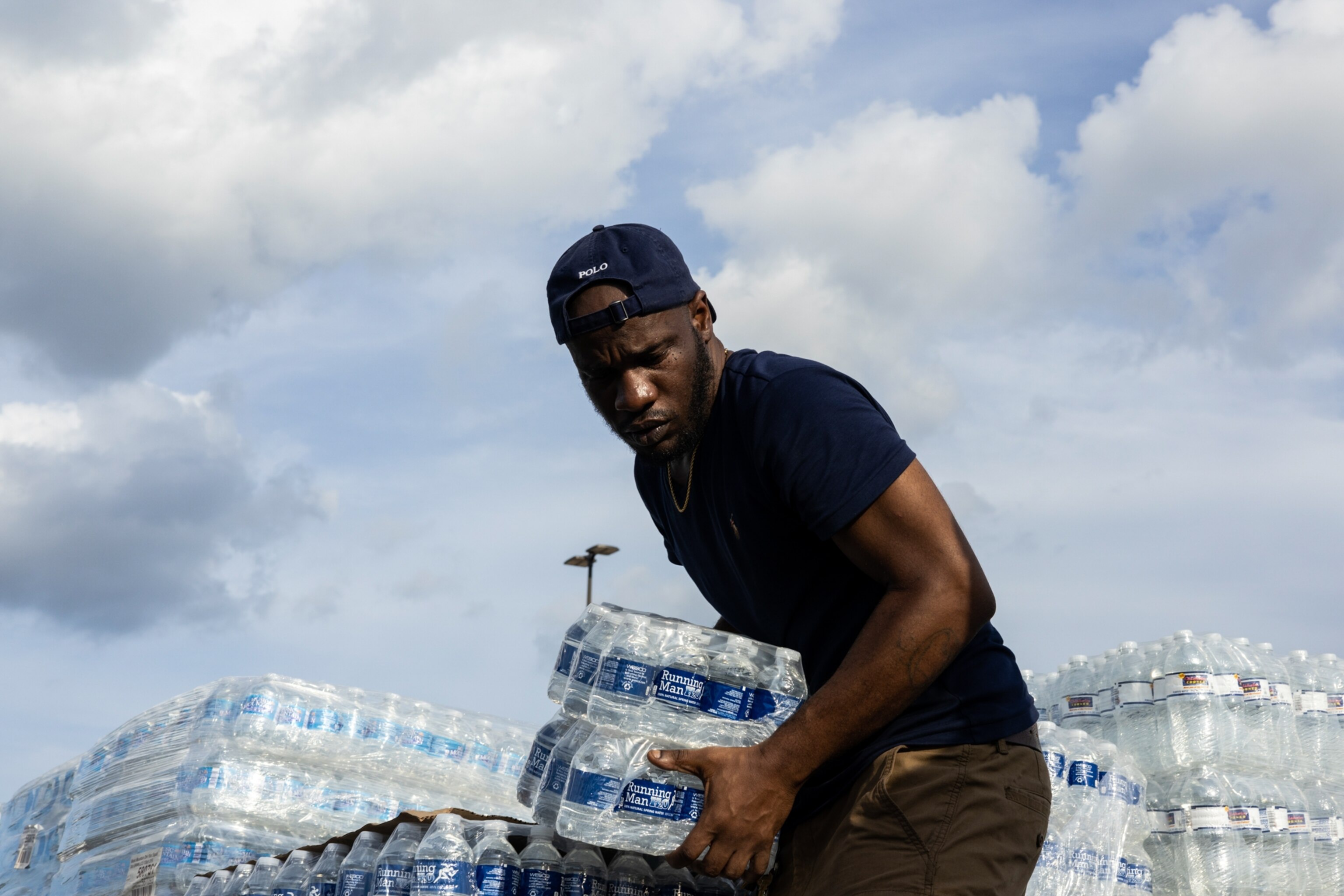 A man picks a case of water to distribute during a water crisis in Mississippi.