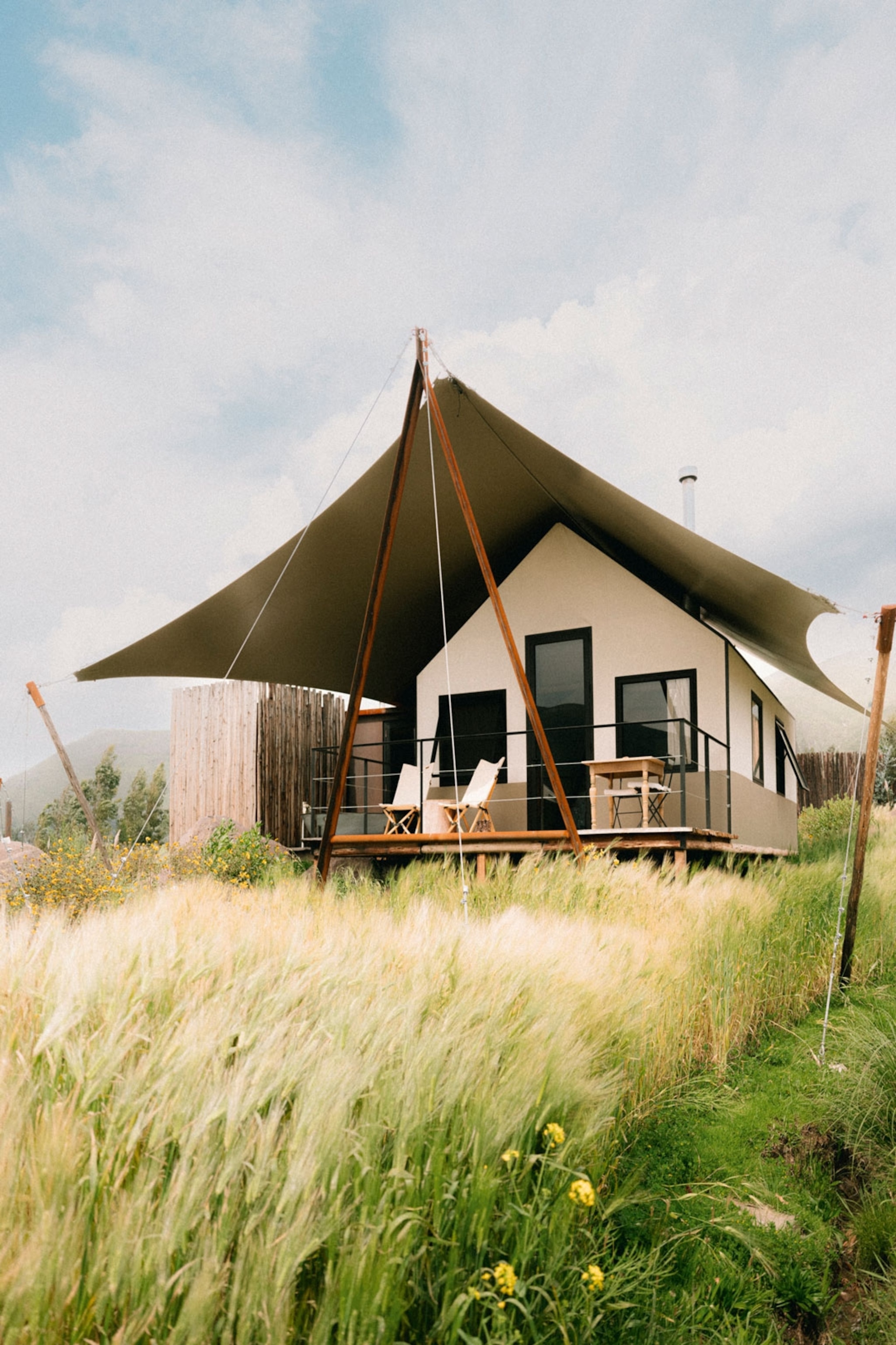 A tent with a canope in a grass field