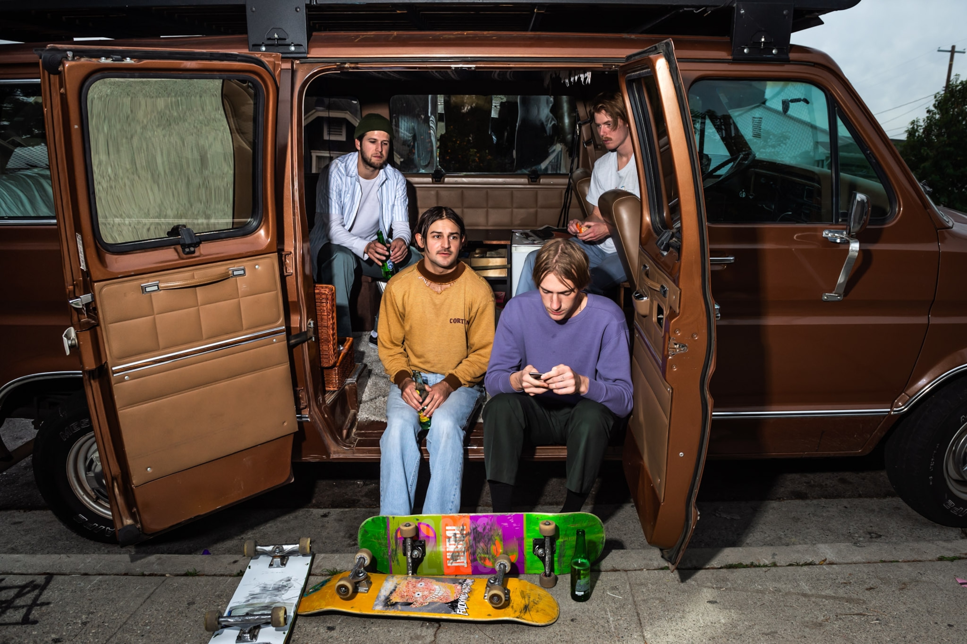 four young adults sitting in a darn brown van