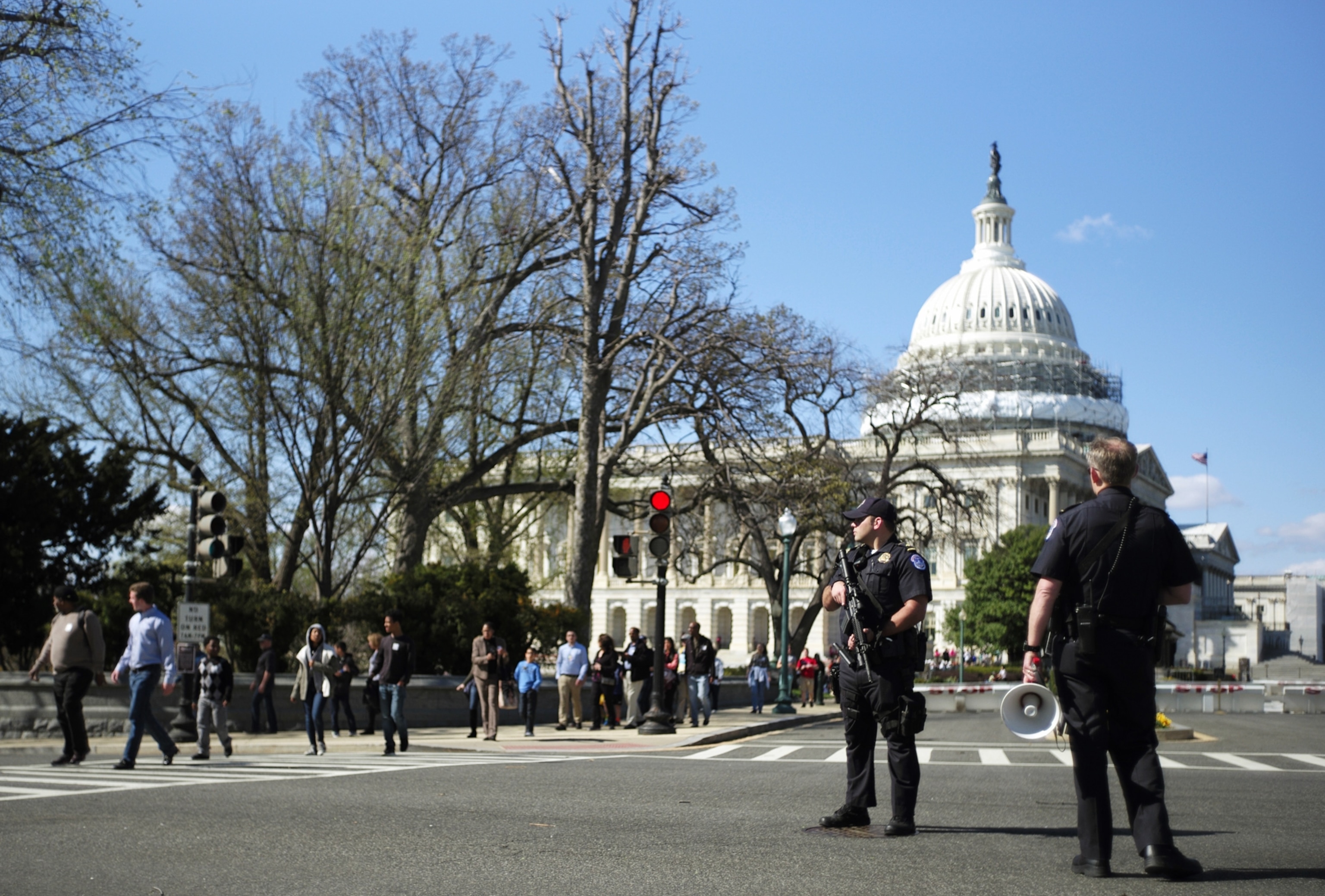 a security guard standing in front of the Capitol while people evacuate