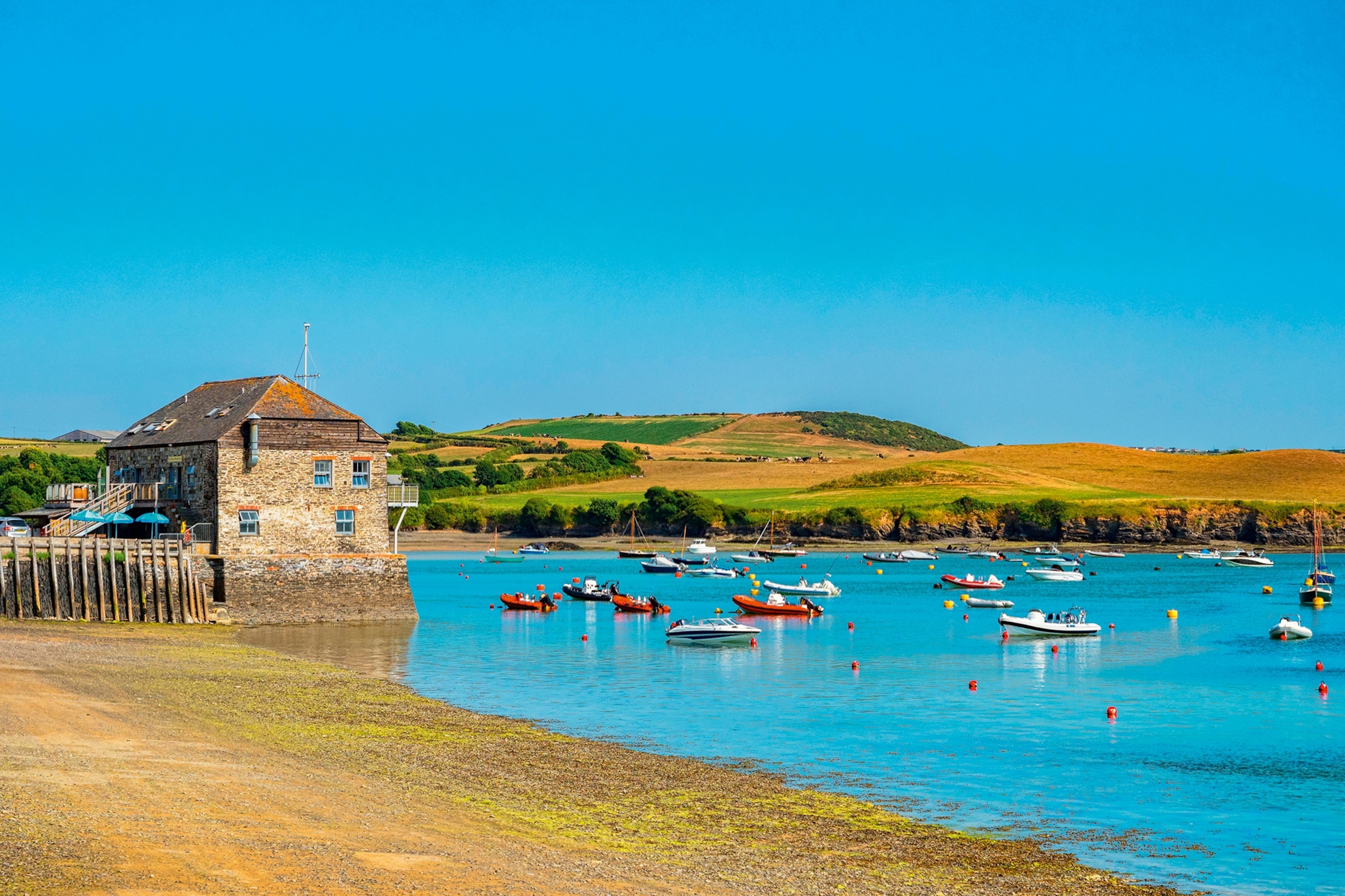 Boats on the water at Camel Estuary in Cornwall, hills in the background.