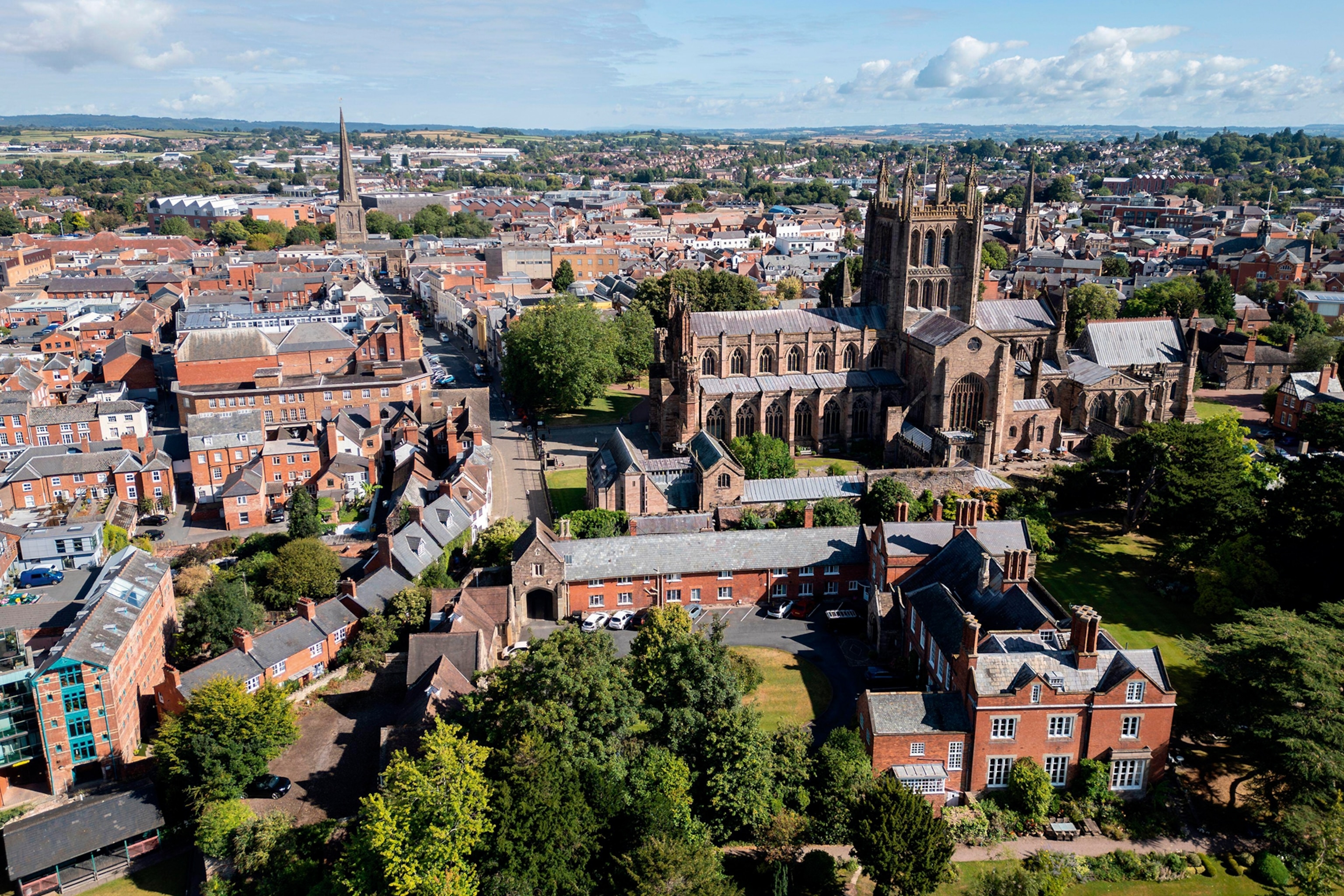 A view onto a typical British town with a couple of churches rising between the brick houses.