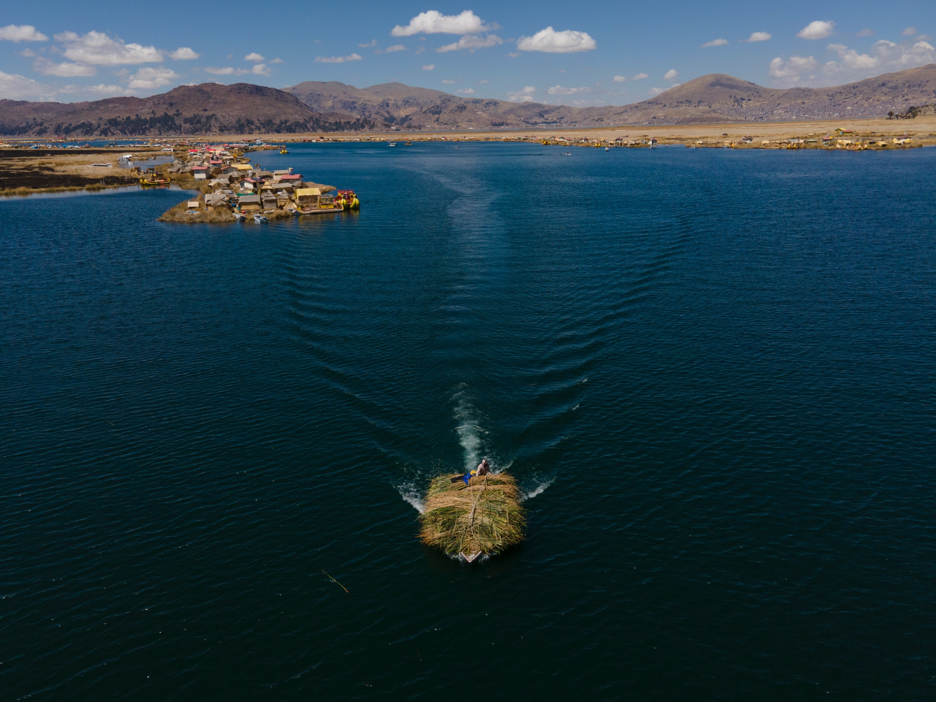 A boat loaded with totora returns to the Uros community in Peru. Totora is a grass that grows in the lake and has been fundamentally important for the subsistence of communities ancestrally. During droughts, it was very difficult to obtain it, and the inhabitants had to travel for several days to collect it.