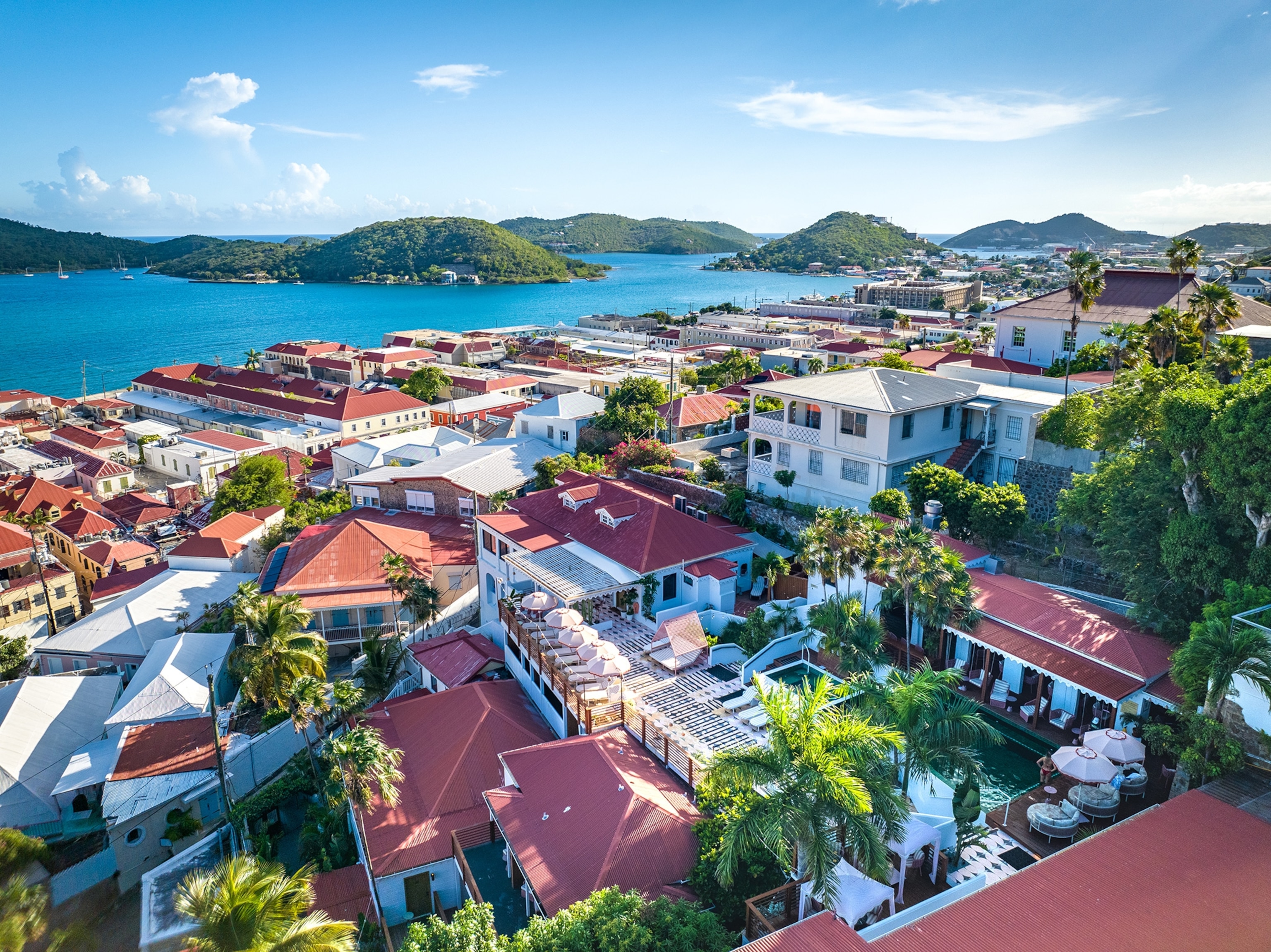 The Pink Palm Hotel from above featuring a view of the Dutch colonial architecture, the picturesque harbor, and islands.