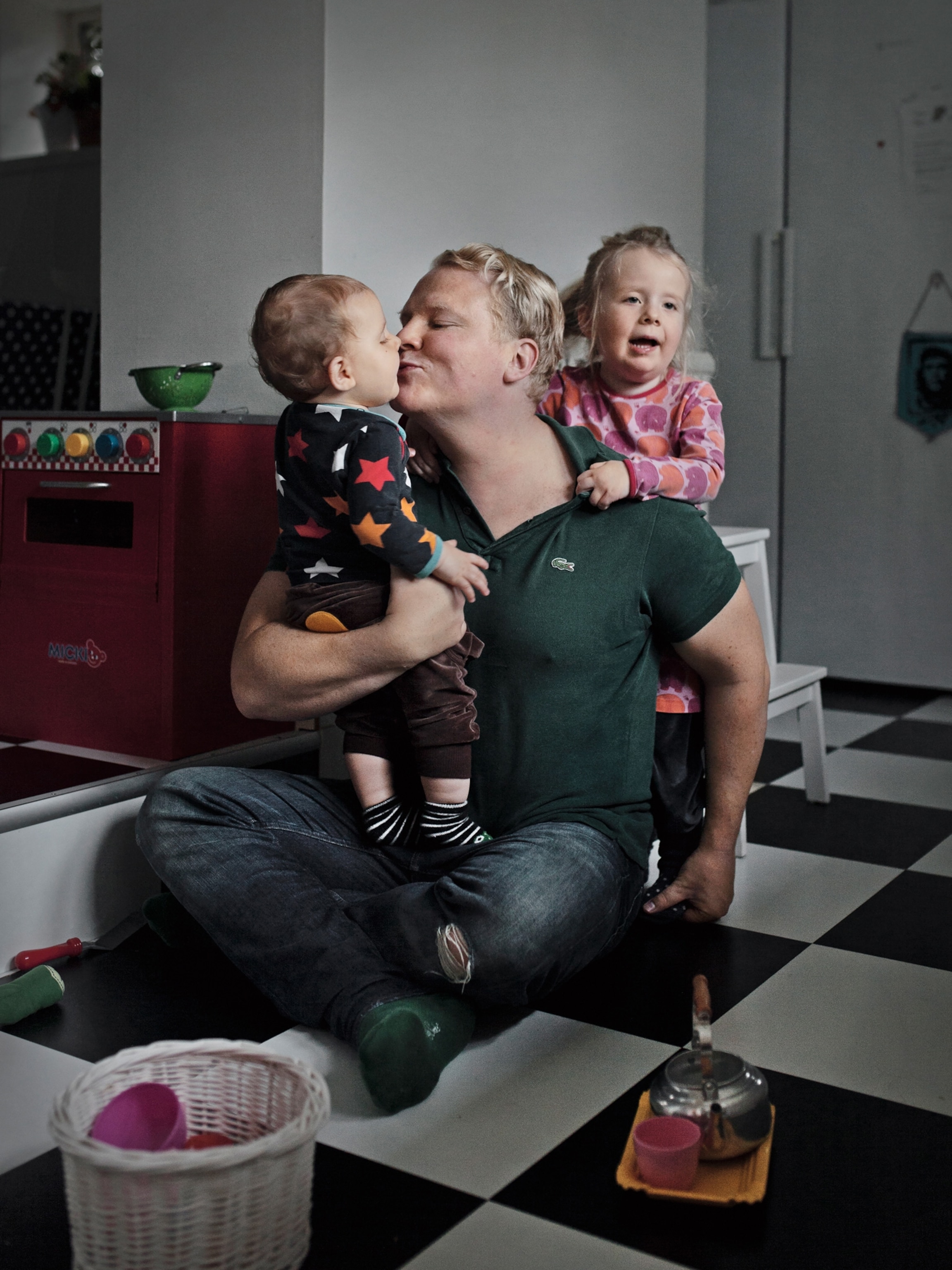 a father kissing one of his two children