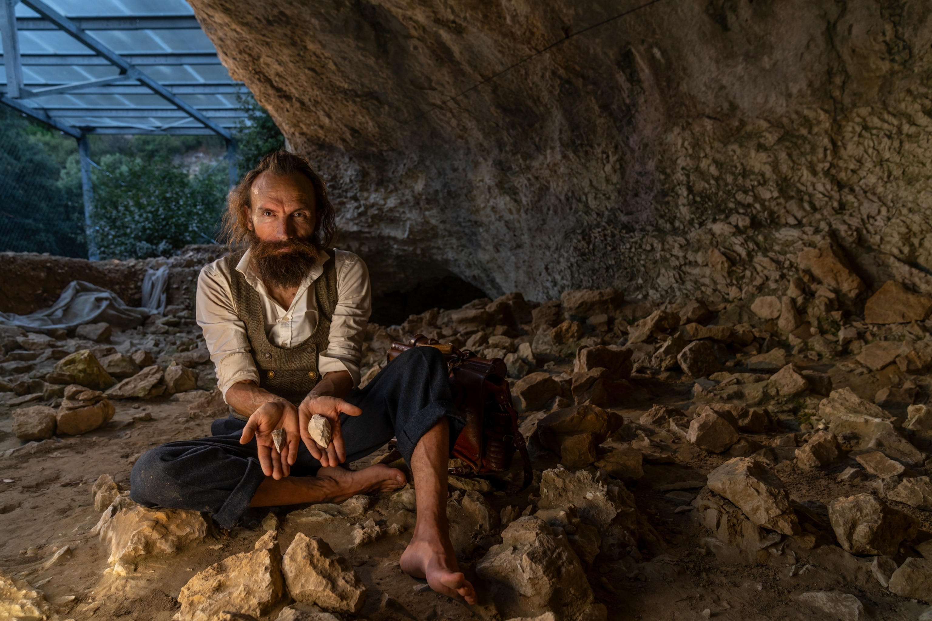 A man holds two stone points in his hands.