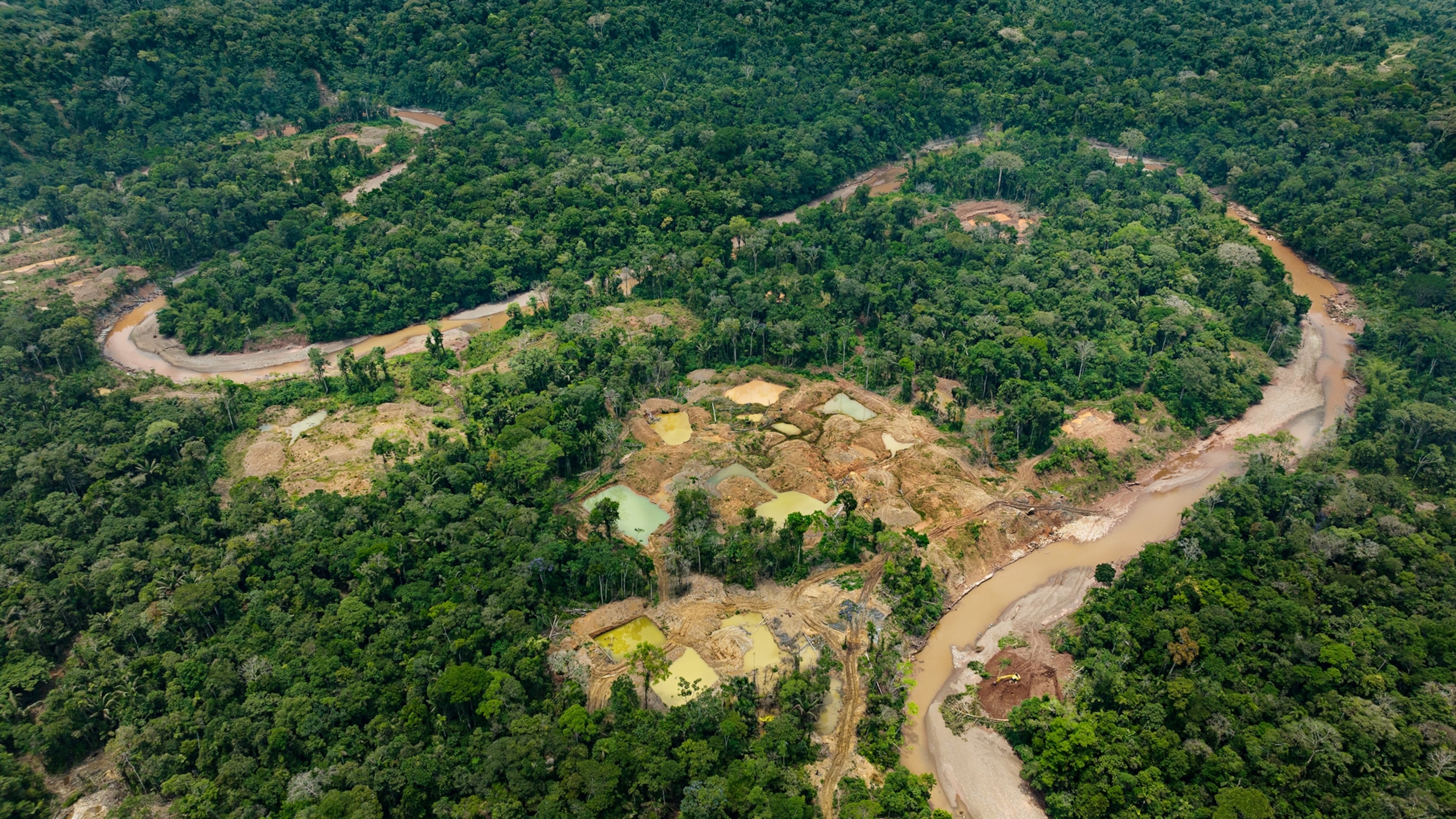 Aerial photo of open pits from illegal gold mining by outsiders on the Bermeja River, in the Cofan Bermejo Ecological Reserve of the Ecuadorian Amazon