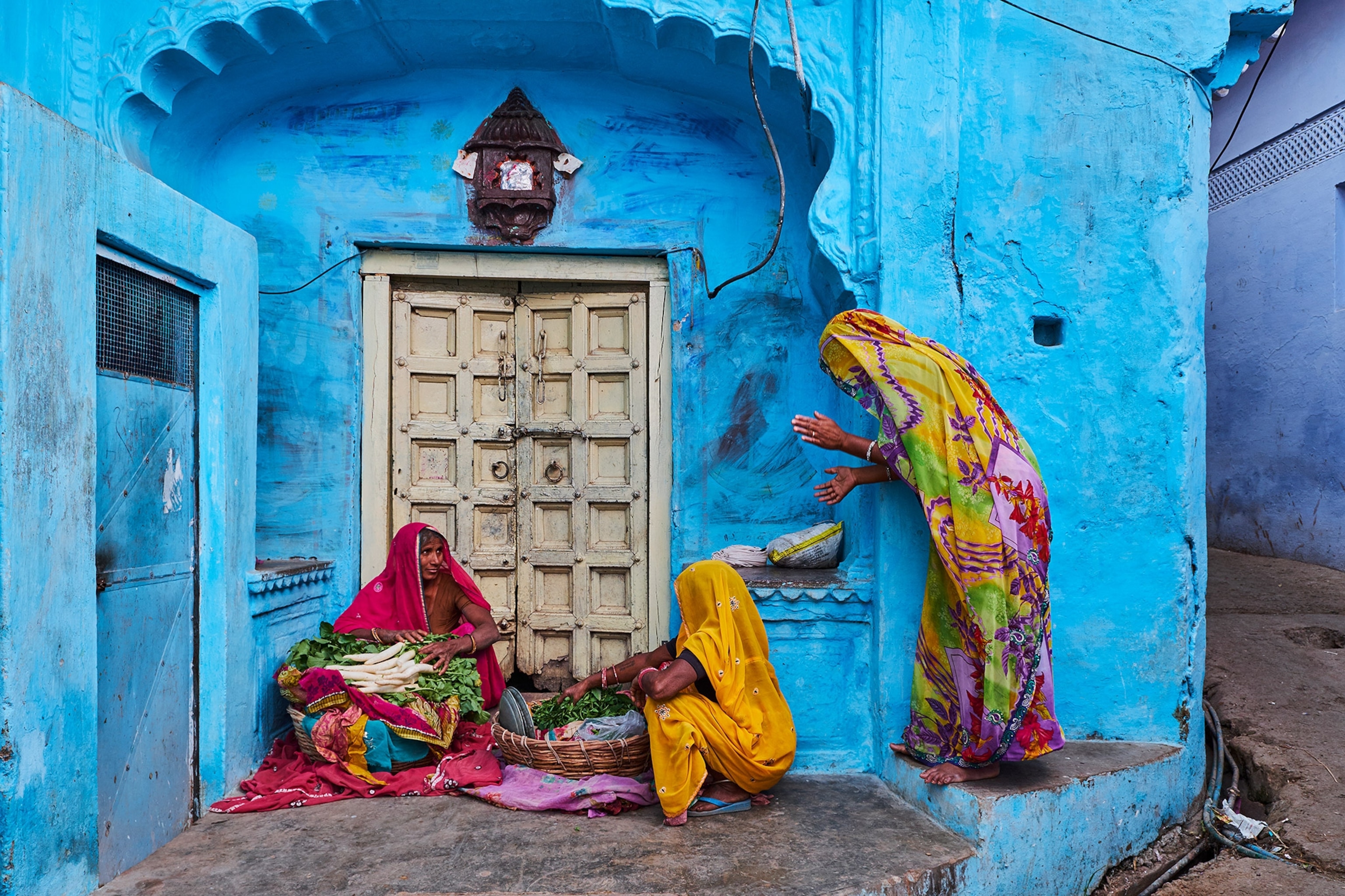 women selling and buying vegetables in saris