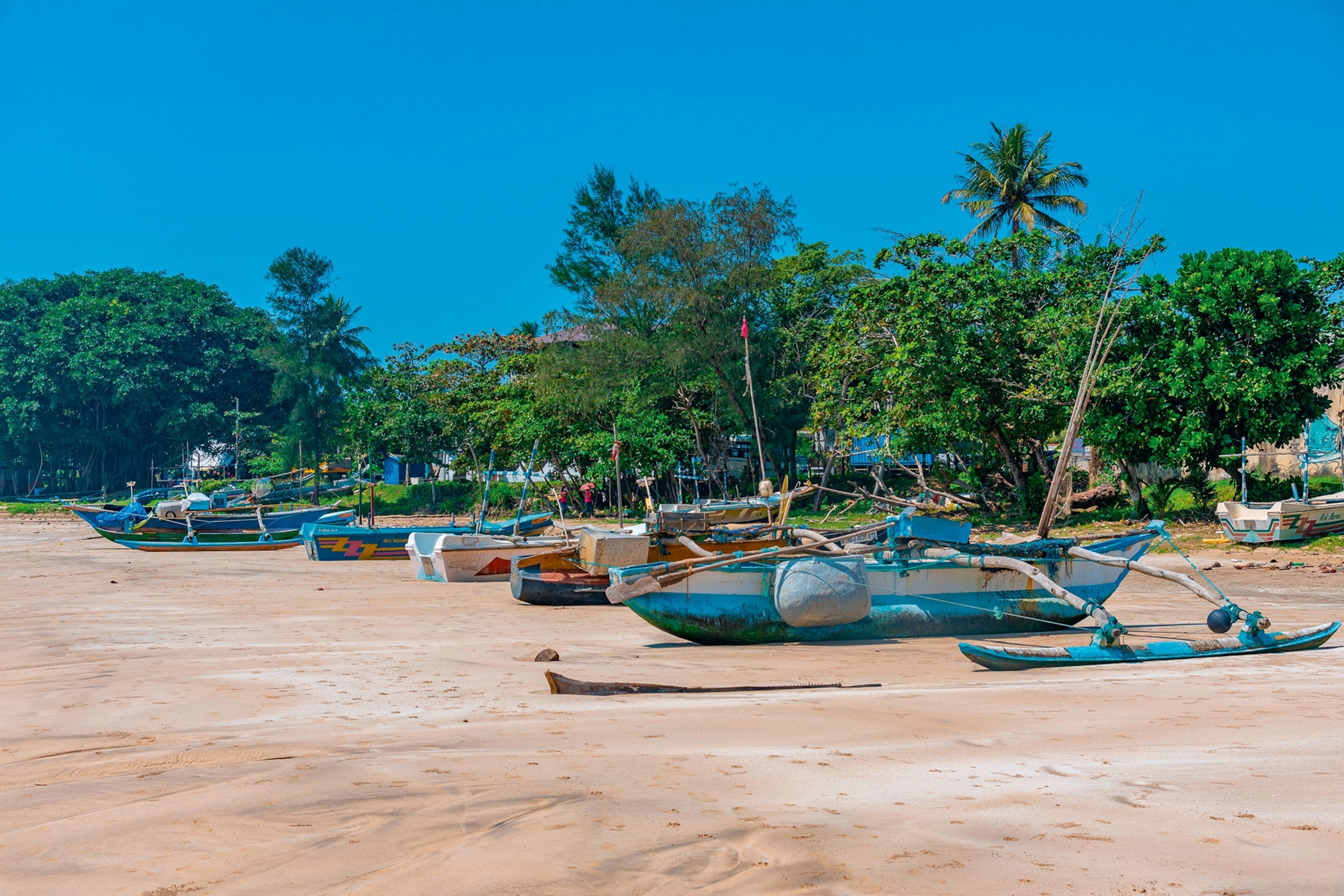Fishing boats moored on a white sand beach
