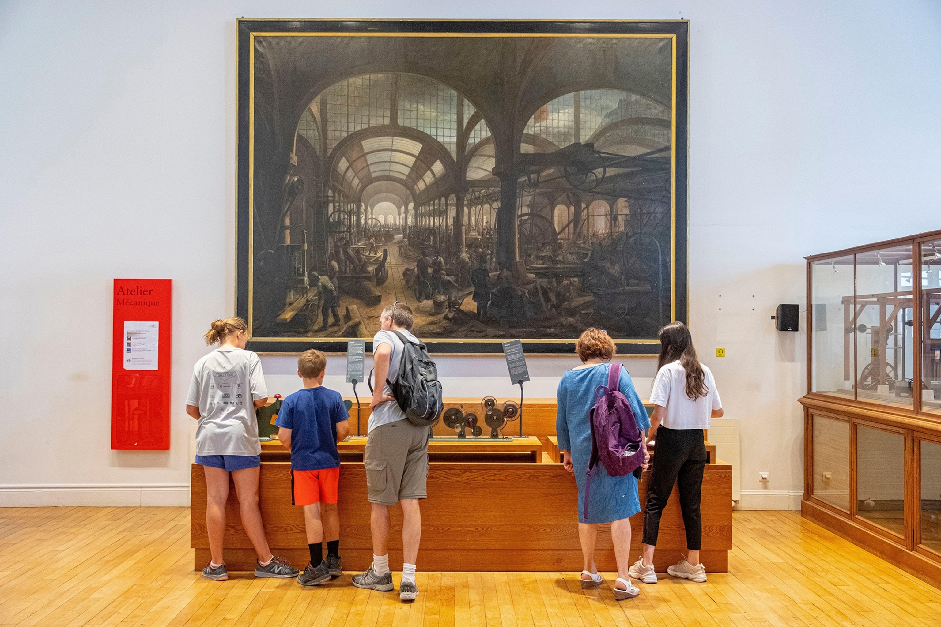 Two families looking at an exposition in a museum
