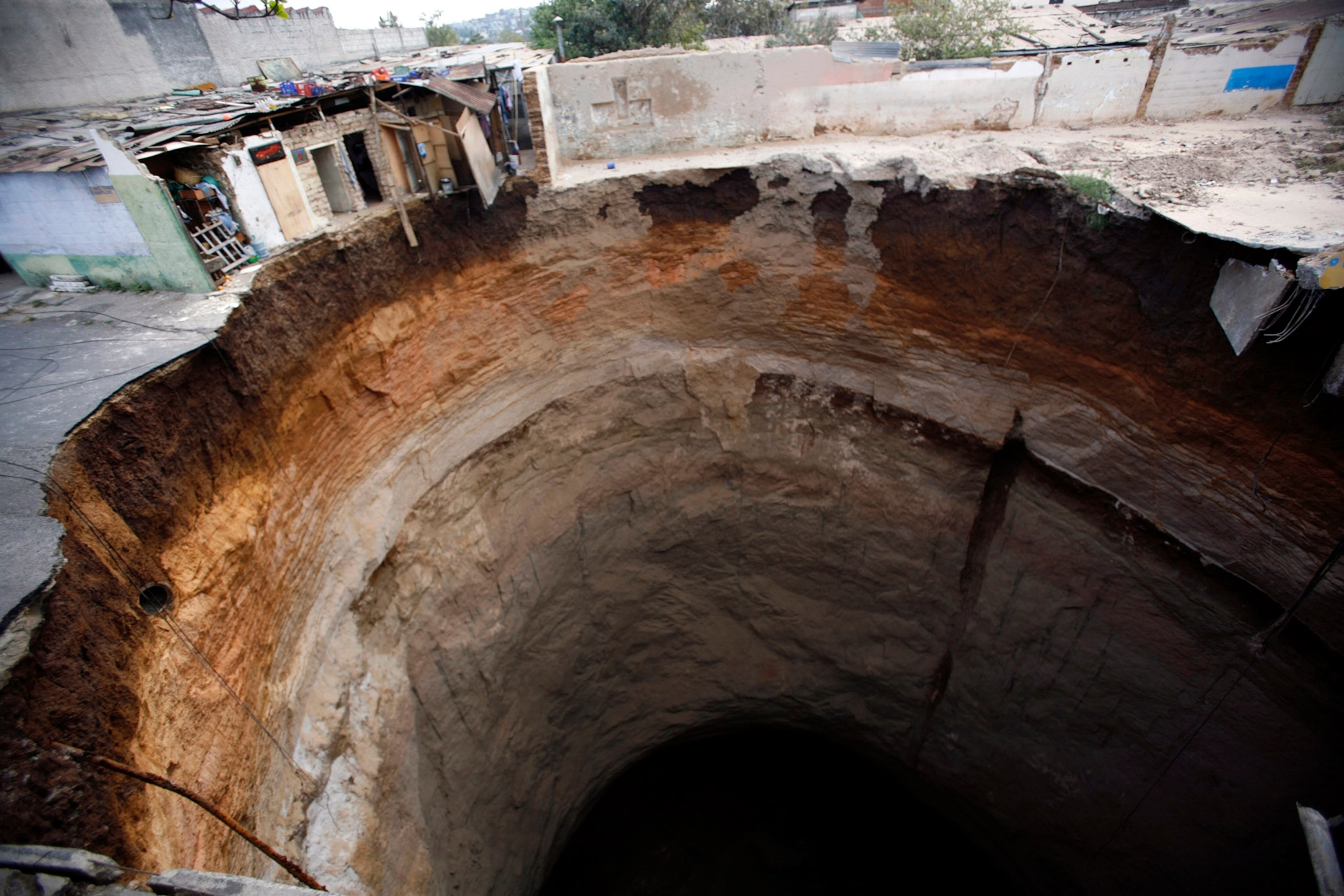 Kim Russell, left, who lives nearby on Gilbralter Street and her mother Betty Box both examine the massive sinkhole that opened on Eldridge Road in Spring Hill, Fla., Saturday. T