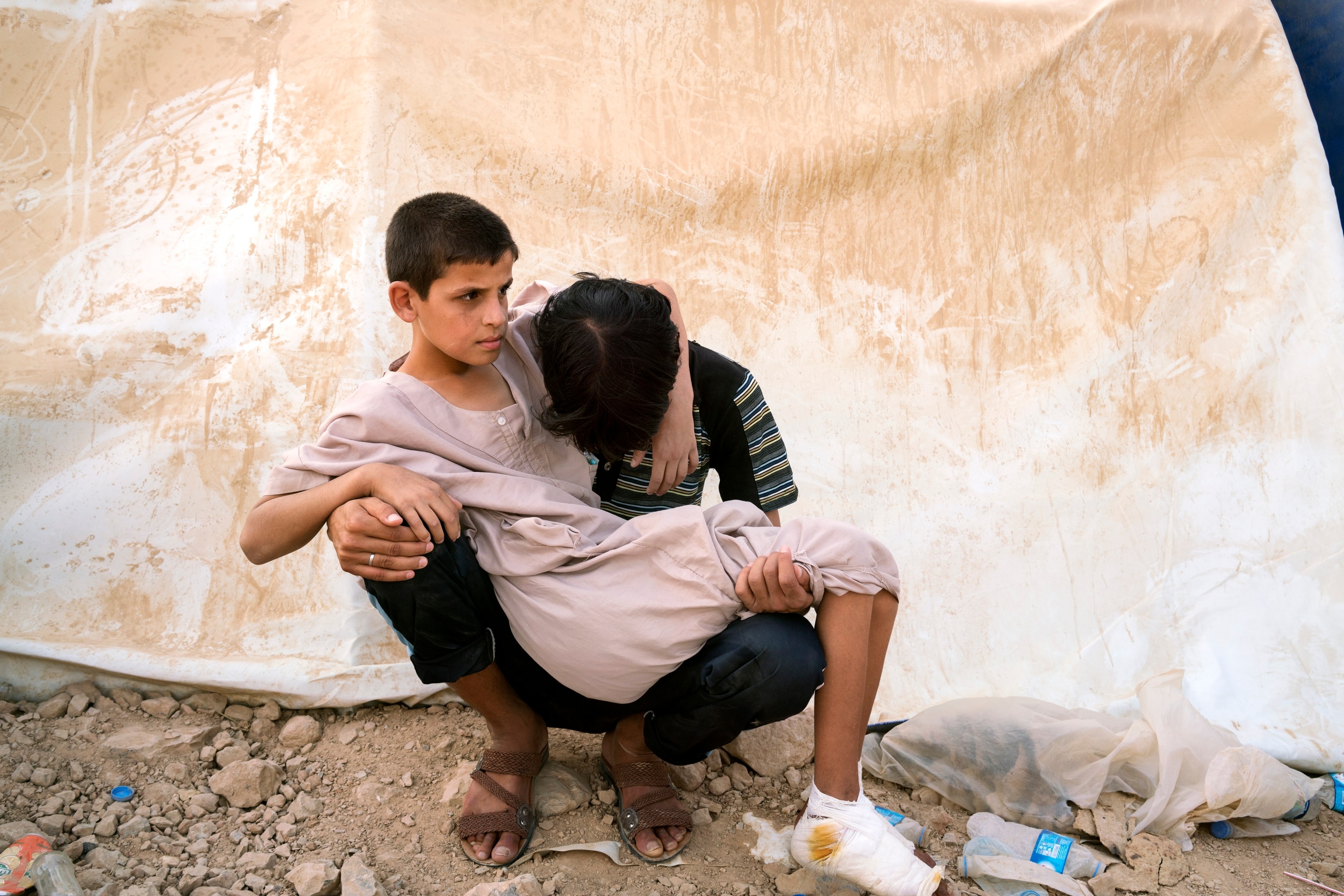 a boy holding his injured younger brother