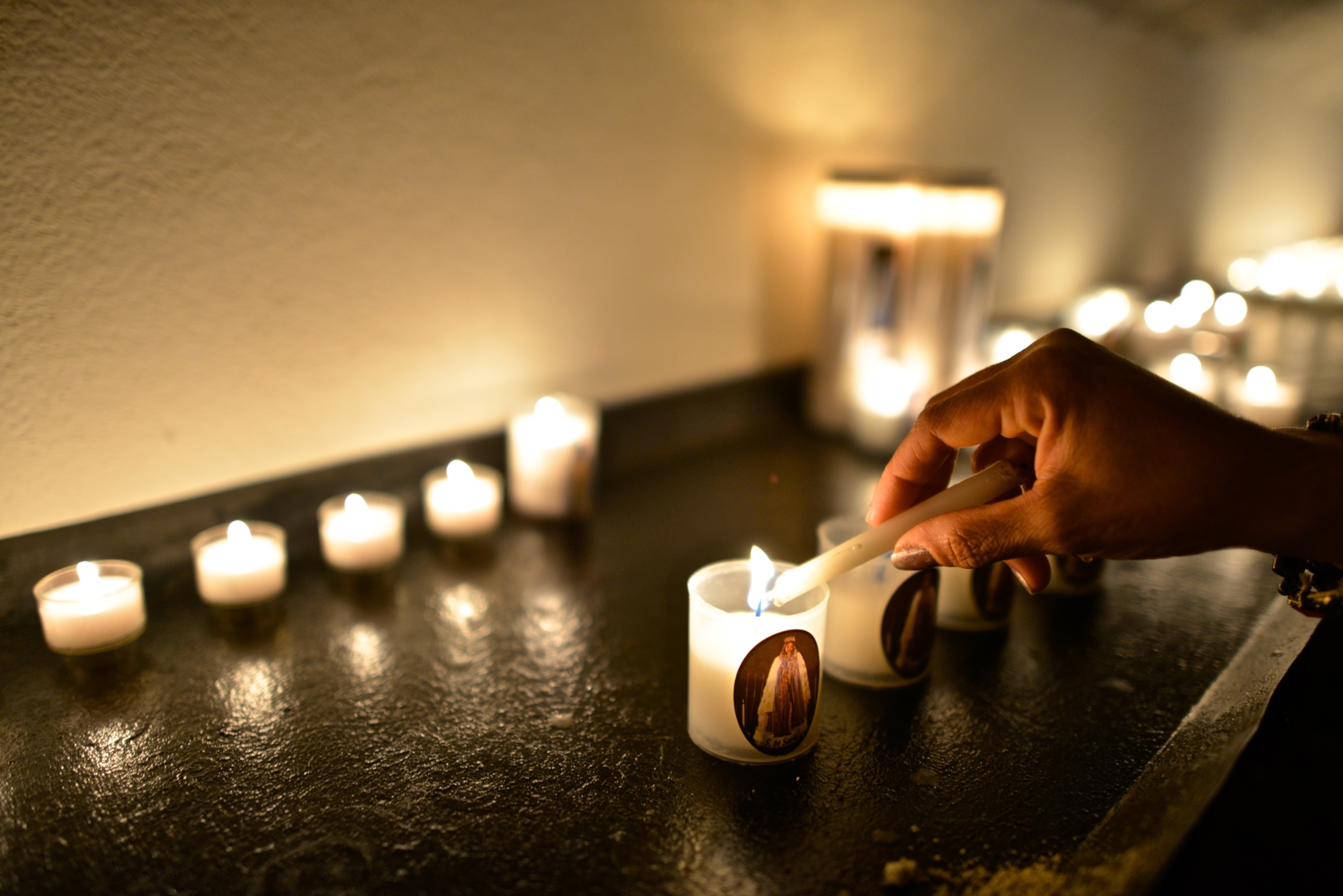A Roma pilgrim lights a candle to worship at the statue of Sara in the crypt of the church.
