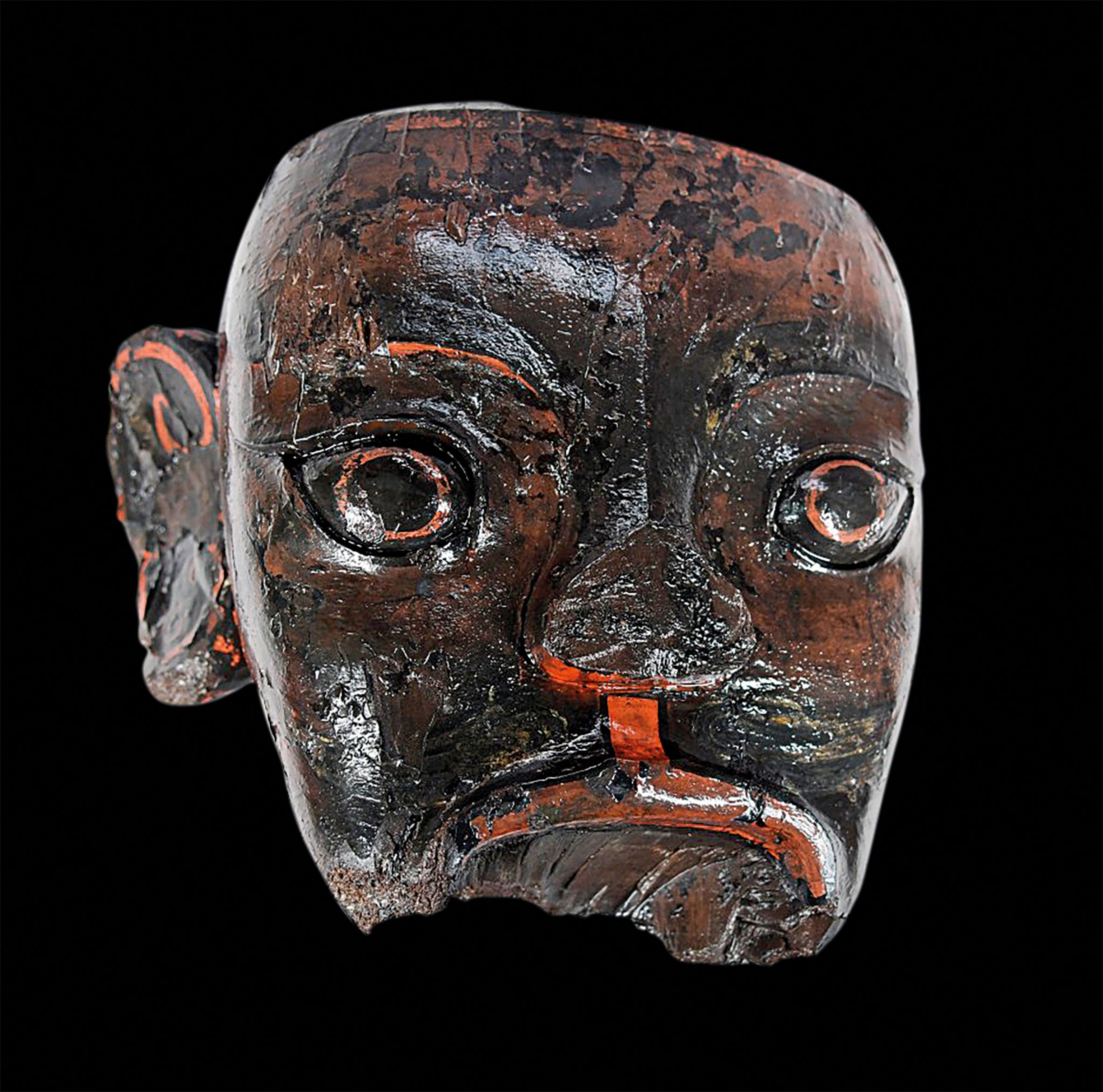 A lacquered wooden head with red accent details