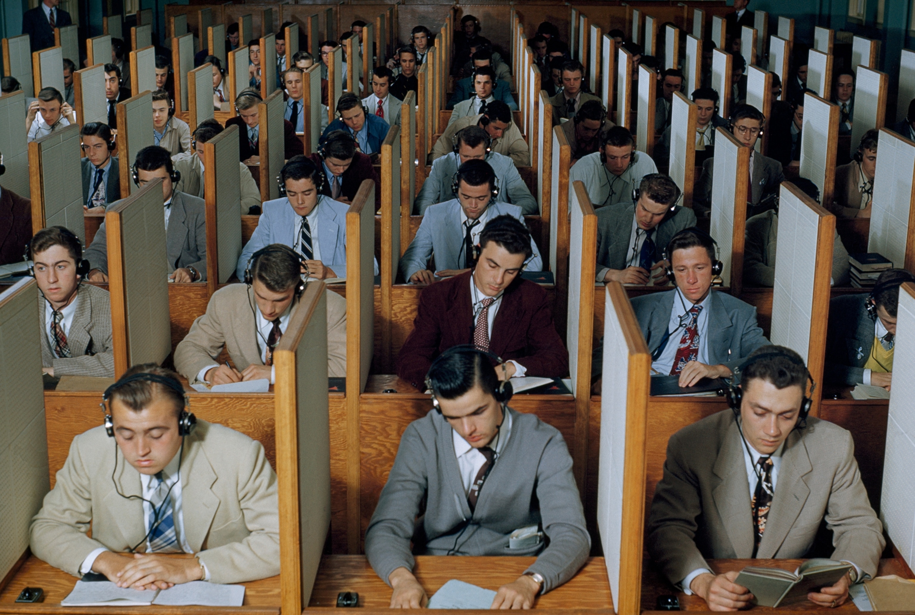 Male students study languages in a large listening lab.
